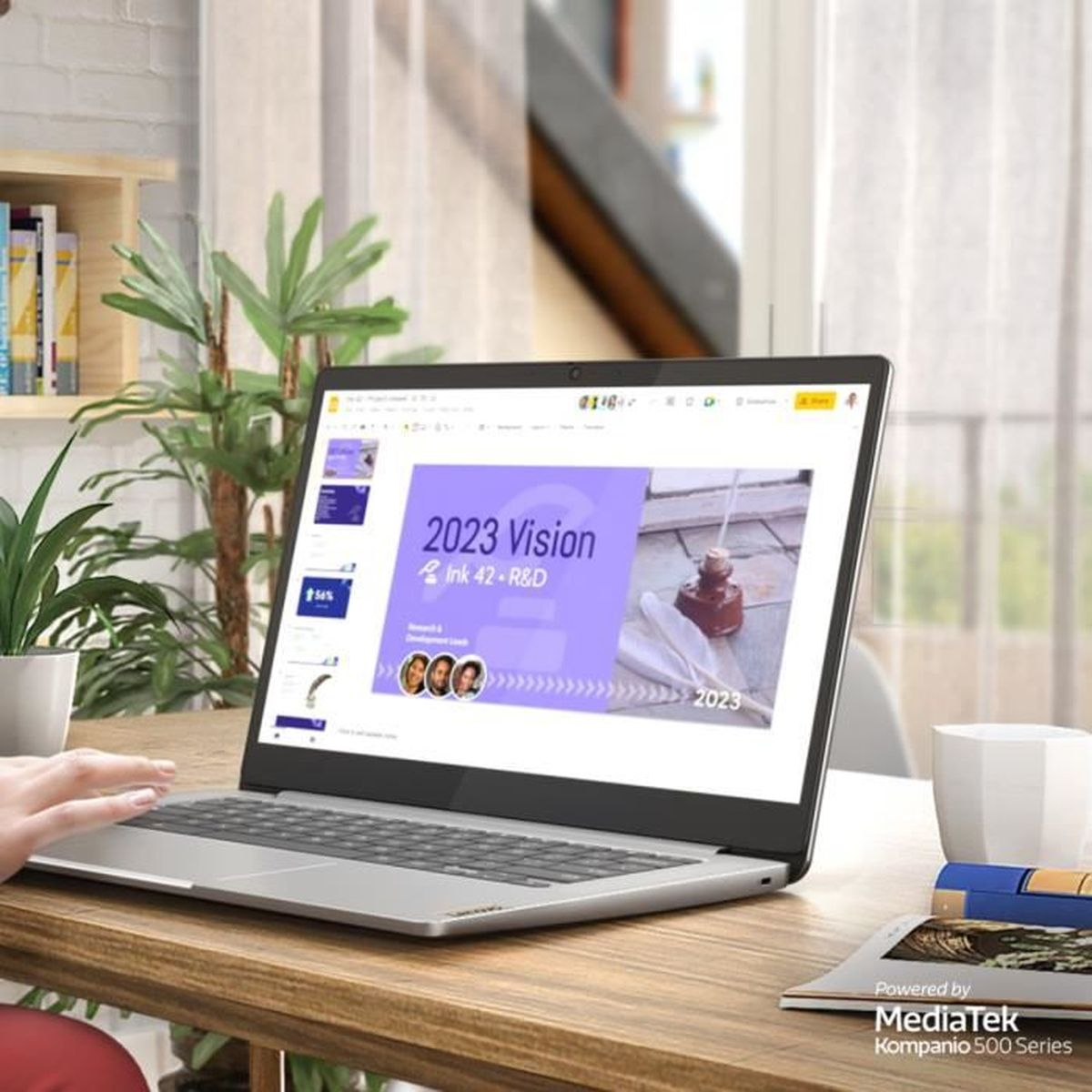 Laptop zeigt Präsentation "2023 Vision Ink 42-R&D" auf Holztisch.