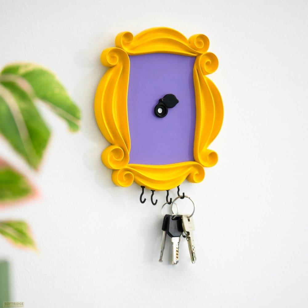 Colgador de llaves amarillo con marco de fotos y centro morado.
