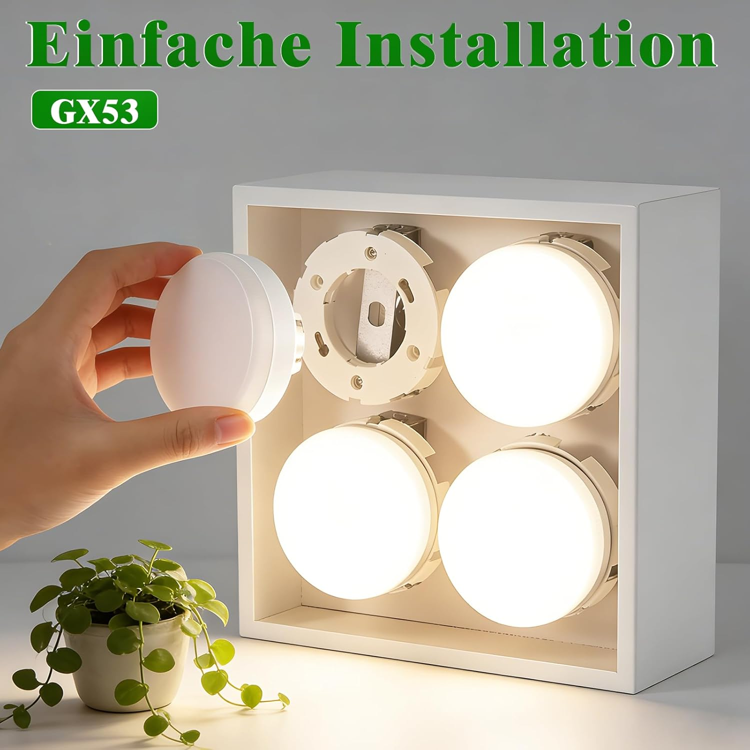 Una mano inserisce una lampada rotonda in un supporto bianco con quattro luci.
