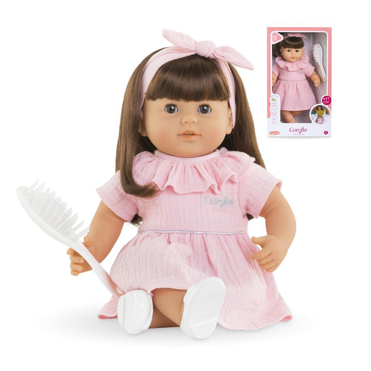 Eine Puppe im rosa Kleid mit einer Bürste.