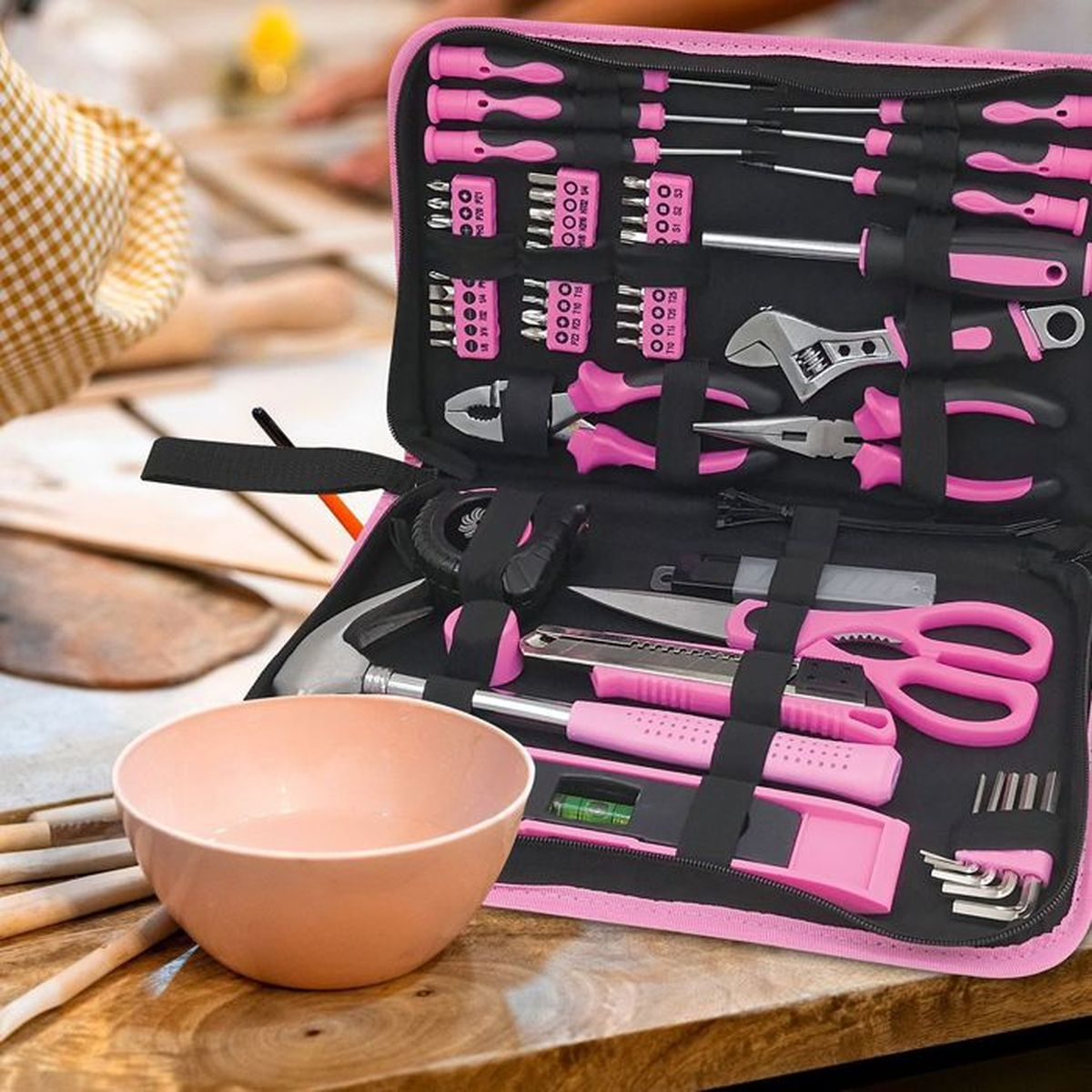 Ein rosa Werkzeugkasten mit verschiedenen Werkzeugen wie Schraubendrehern, Zangen und einer Schere.
