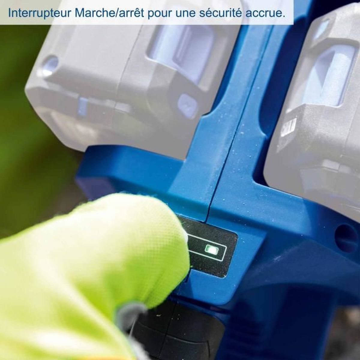 Grüner Handschuh betätigt Ein/Aus-Schalter einer blauen Maschine mit Batterien.