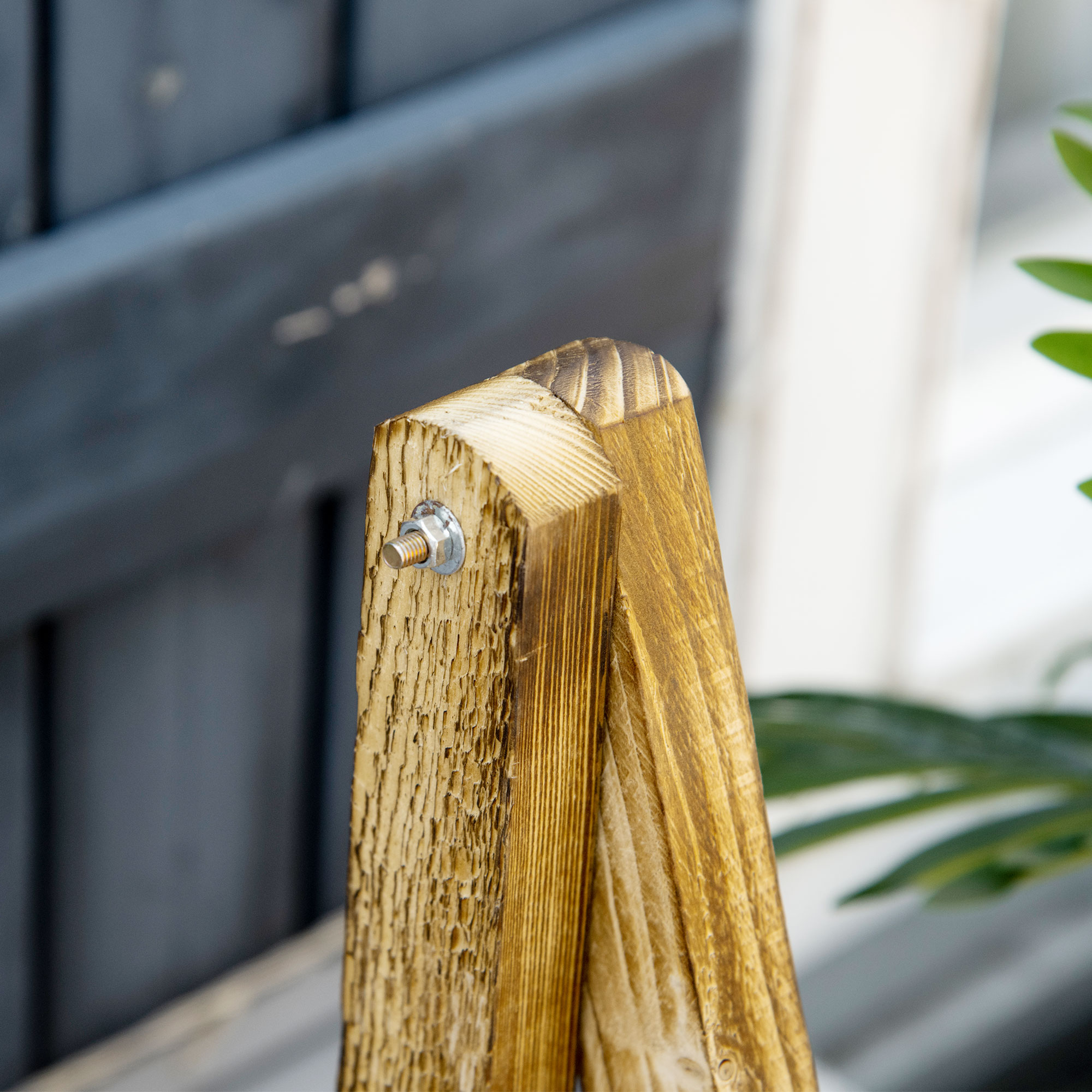 Estructura de madera con perno y tuerca visibles, fondo borroso