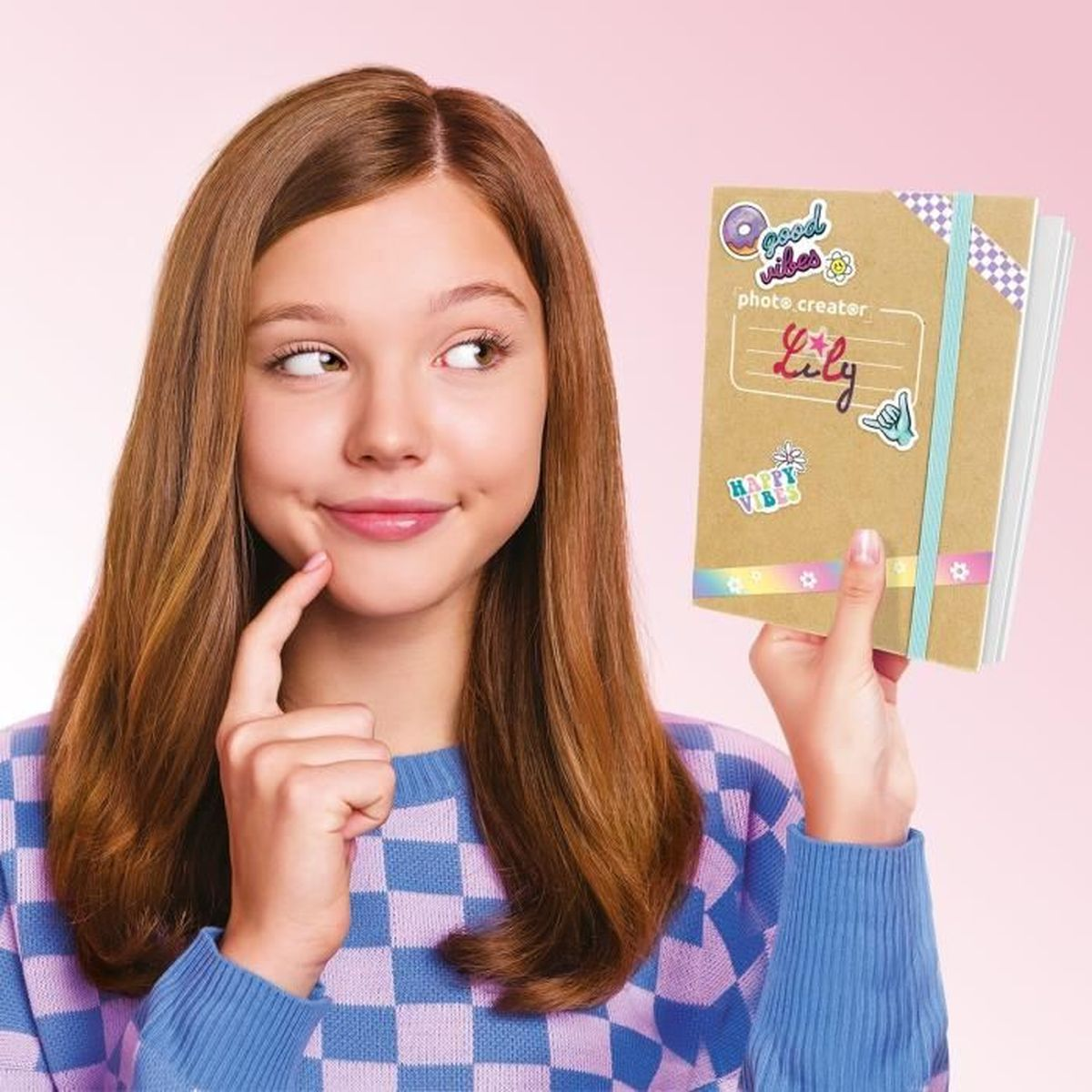 Ein Mädchen mit braunen Haaren hält ein Notizbuch mit Aufklebern.