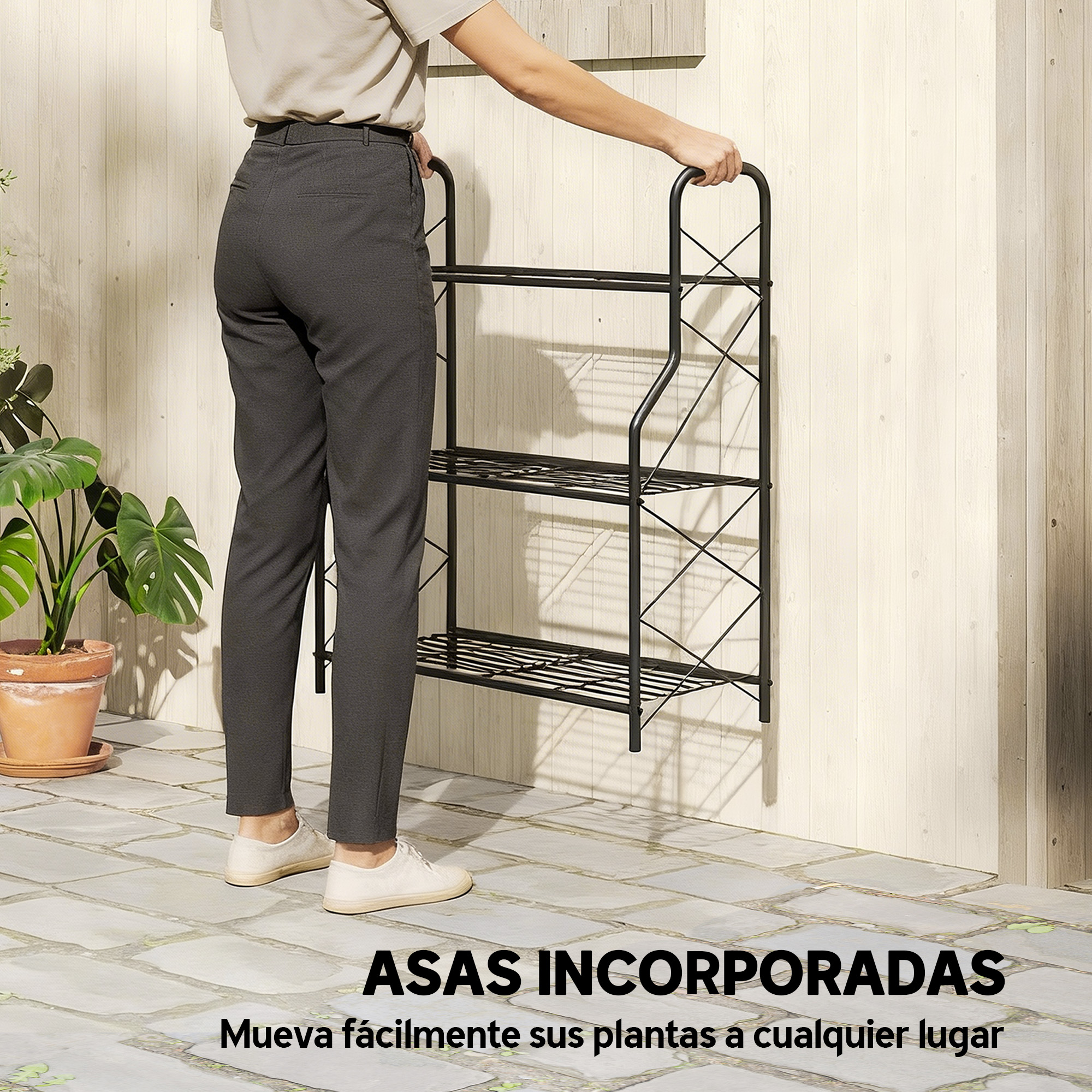 Una persona empuja un estante negro de tres niveles con asas por una pared de madera.