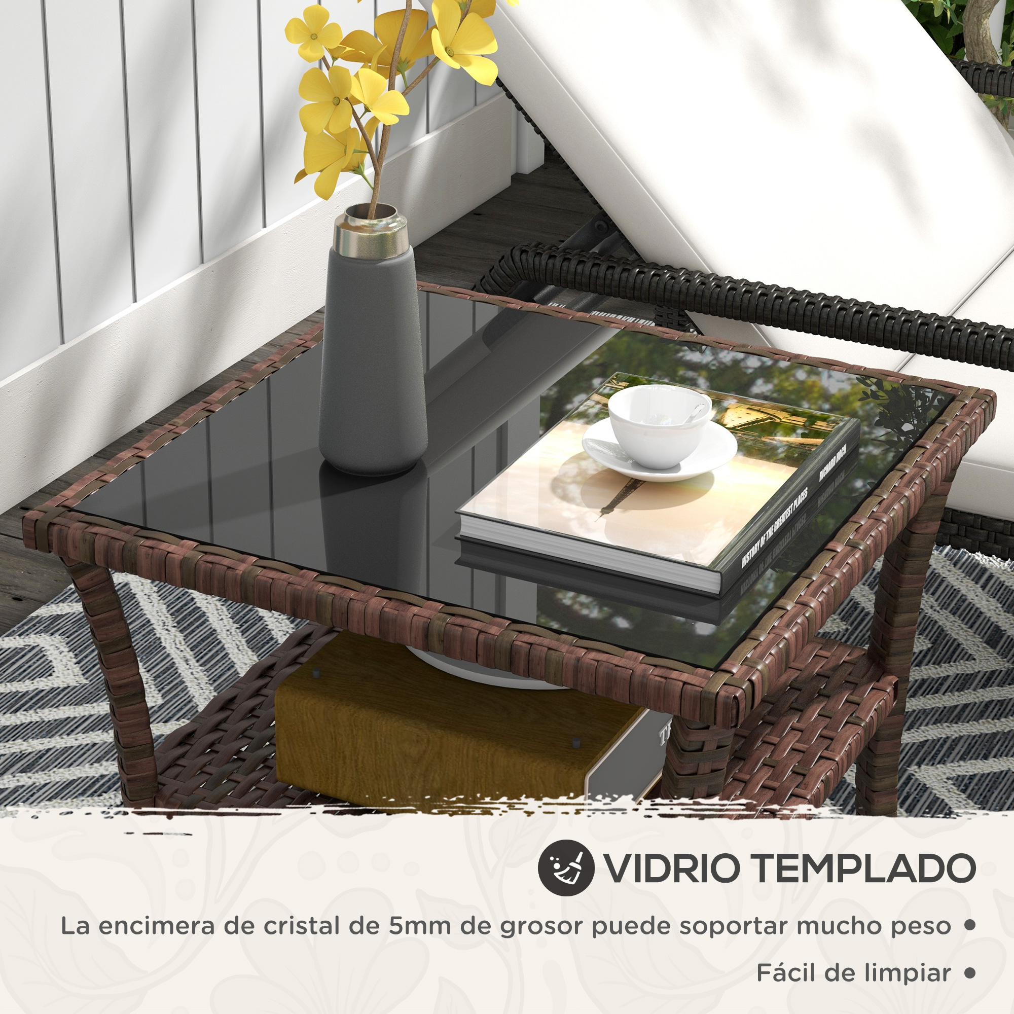Mesa de centro de ratán marrón con tapa de cristal, libro, taza y jarrón.