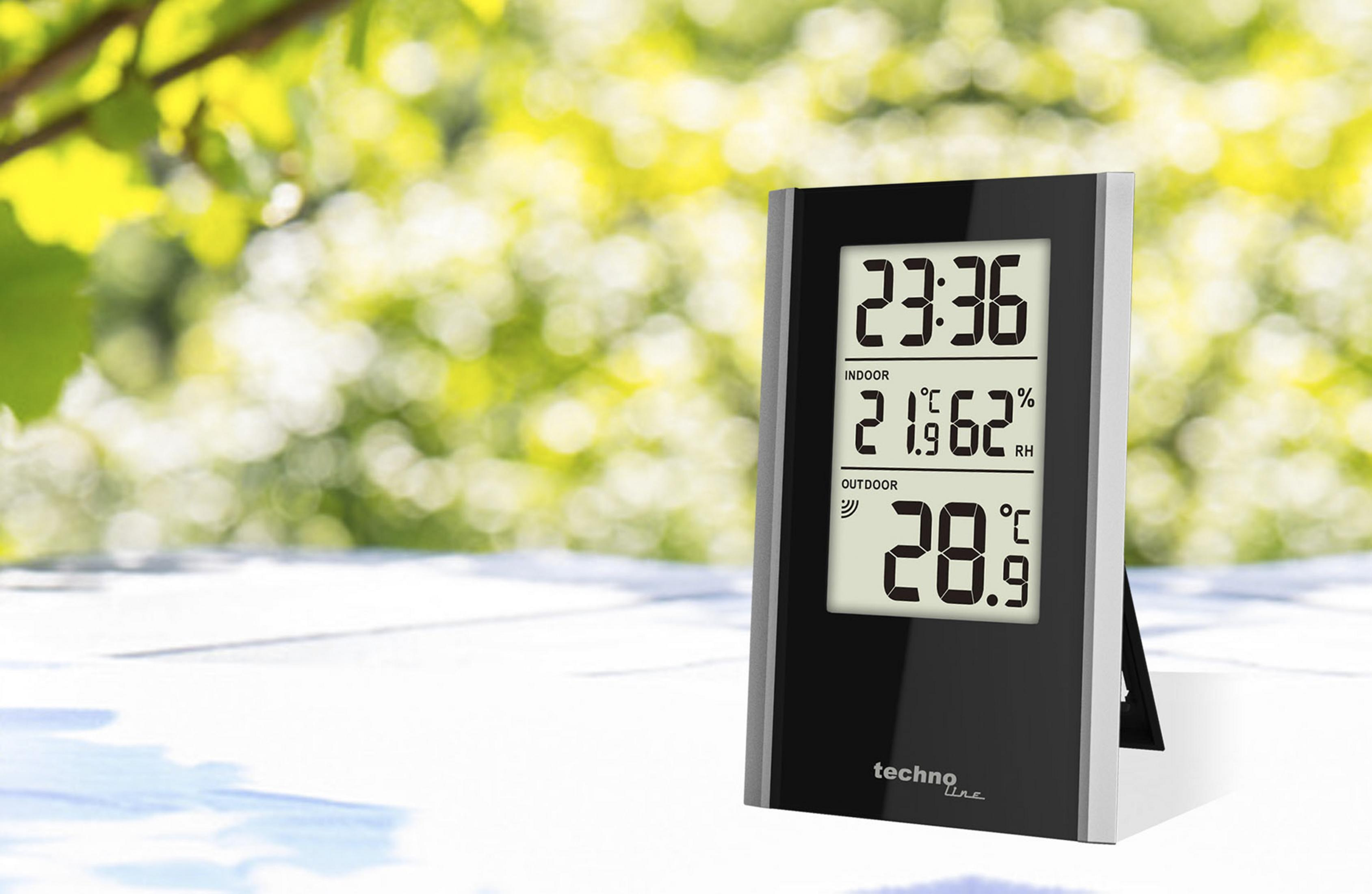 Un thermomètre numérique noir affiche 23:36, 21.9°C intérieur et 28.9°C extérieur.