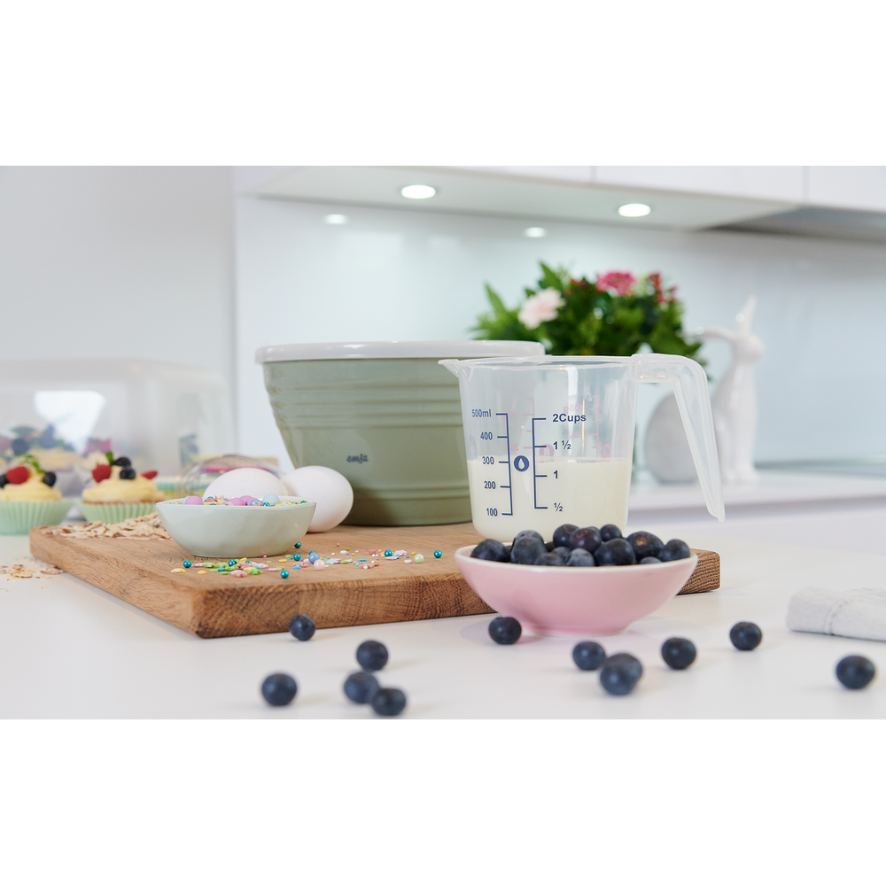 Backzutaten auf einem Holzbrett: Eier, Streusel, Blaubeeren, Messbecher, Schüssel.