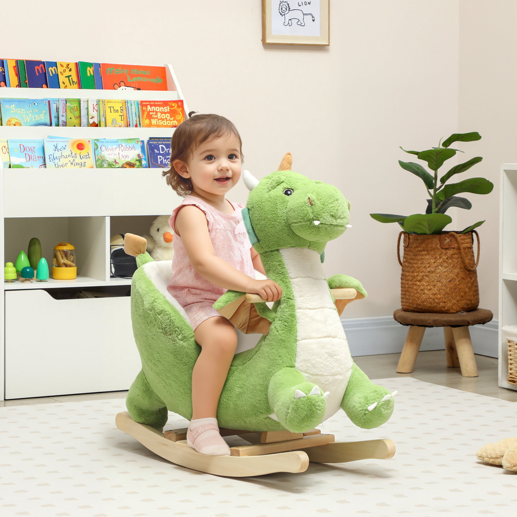 Un niño pequeño monta un balancín de dinosaurio de felpa verde en una habitación infantil con libros.