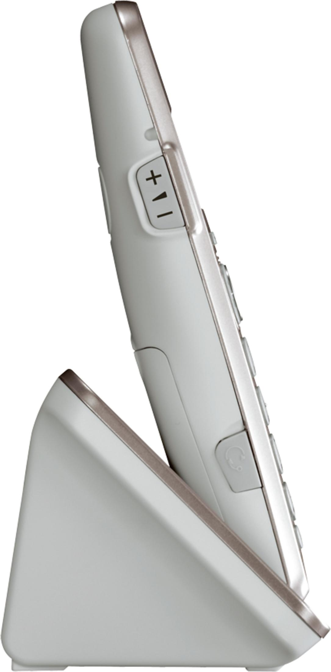 Un telefono cordless bianco riposa sulla sua base di ricarica.