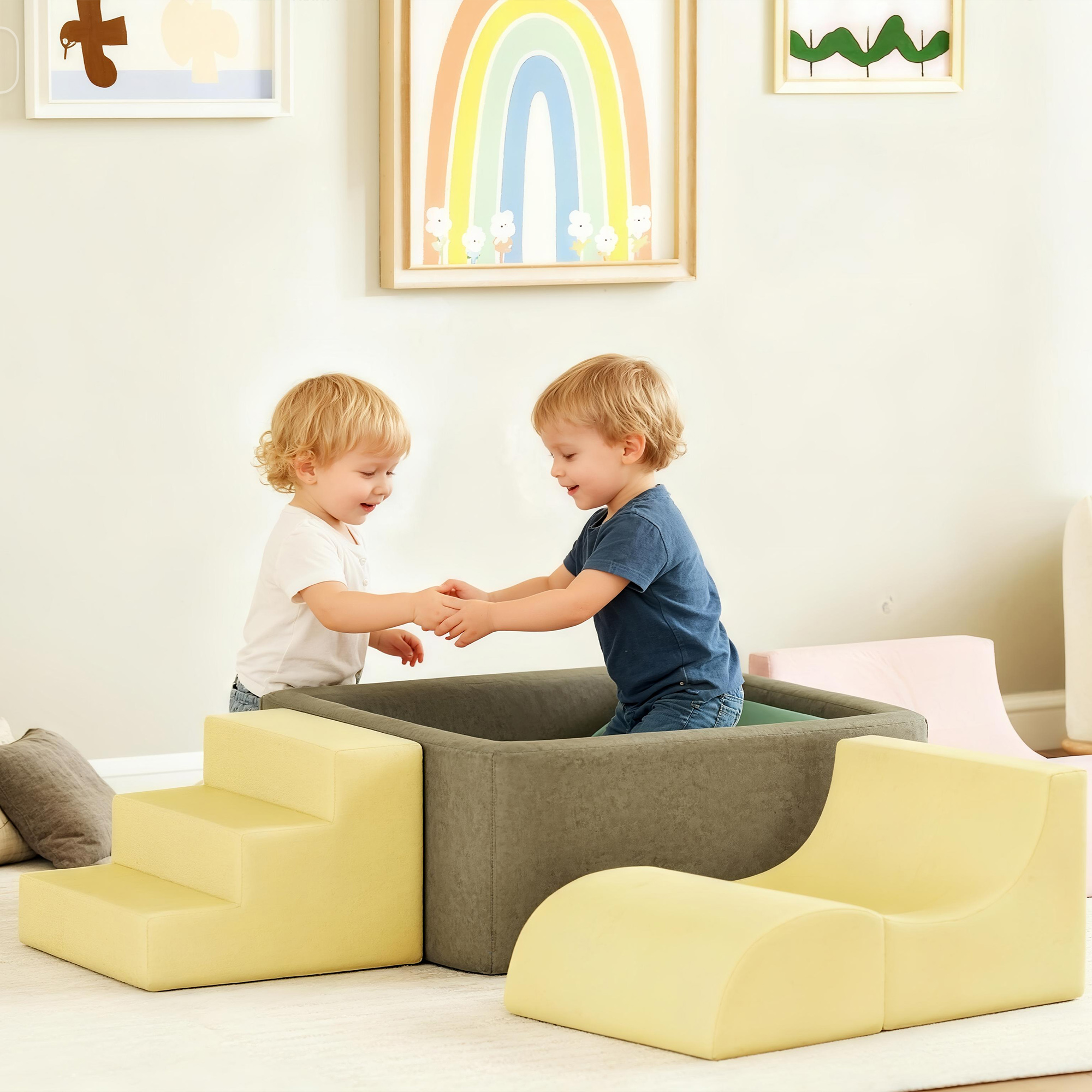 Dos niños rubios juegan en una zona de juegos blandos con muebles de espuma.