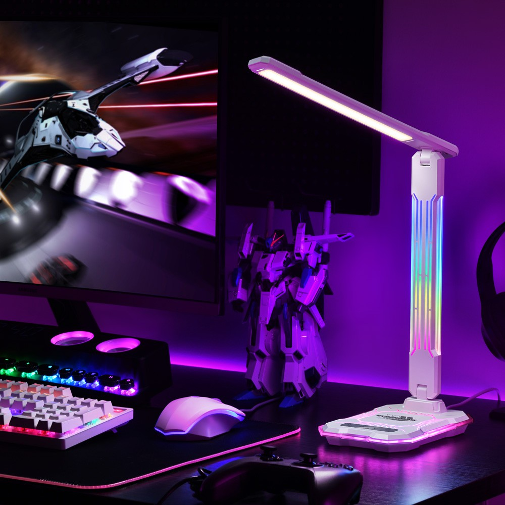 Escritorio con configuración de juegos: Monitor muestra nave espacial, teclado, ratón, mando, figura y lámpara.