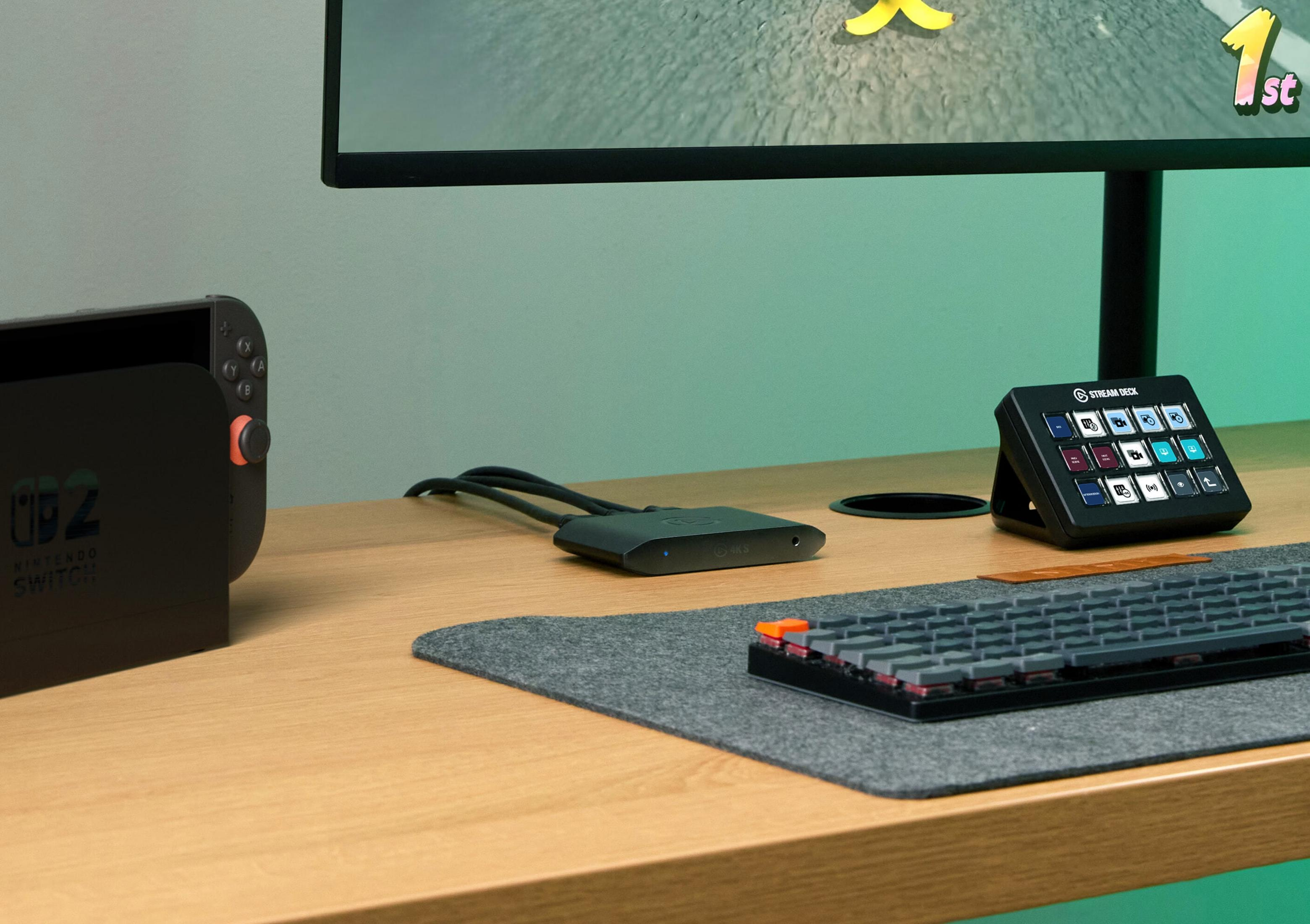 Nintendo Switch, Stream Deck, tastiera, monitor e cavi su una scrivania.