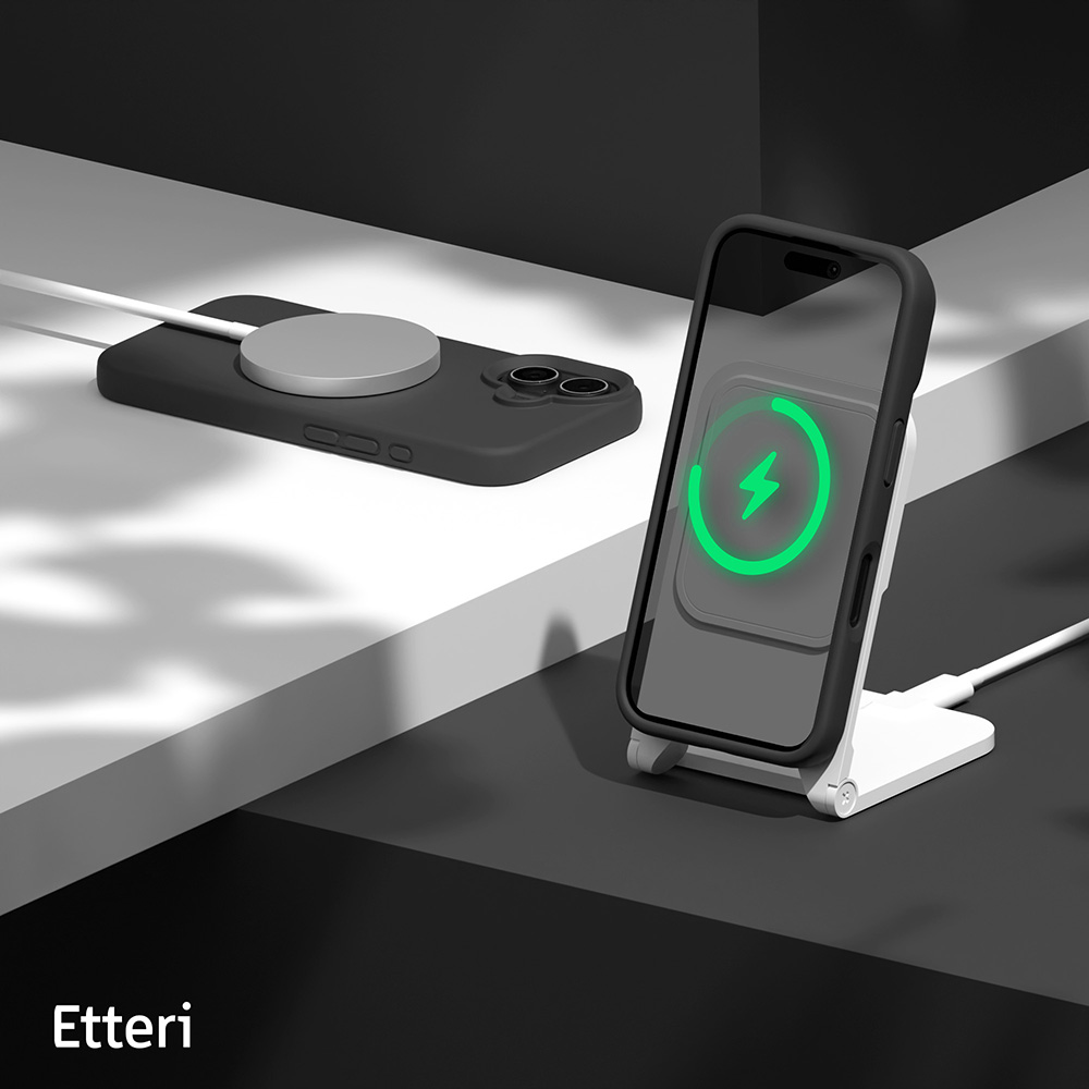 Ein schwarzes iPhone lädt auf einem weißen Ständer. Ein anderes iPhone liegt daneben.