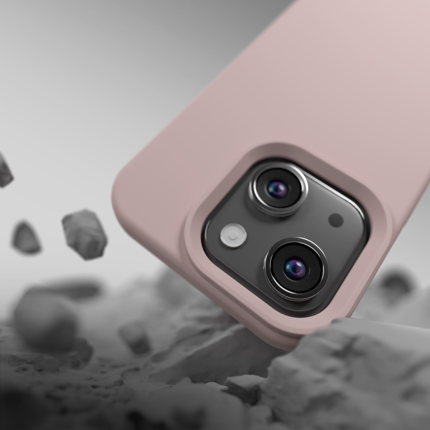 Una cover rosa per telefono con fotocamera cade su rocce.