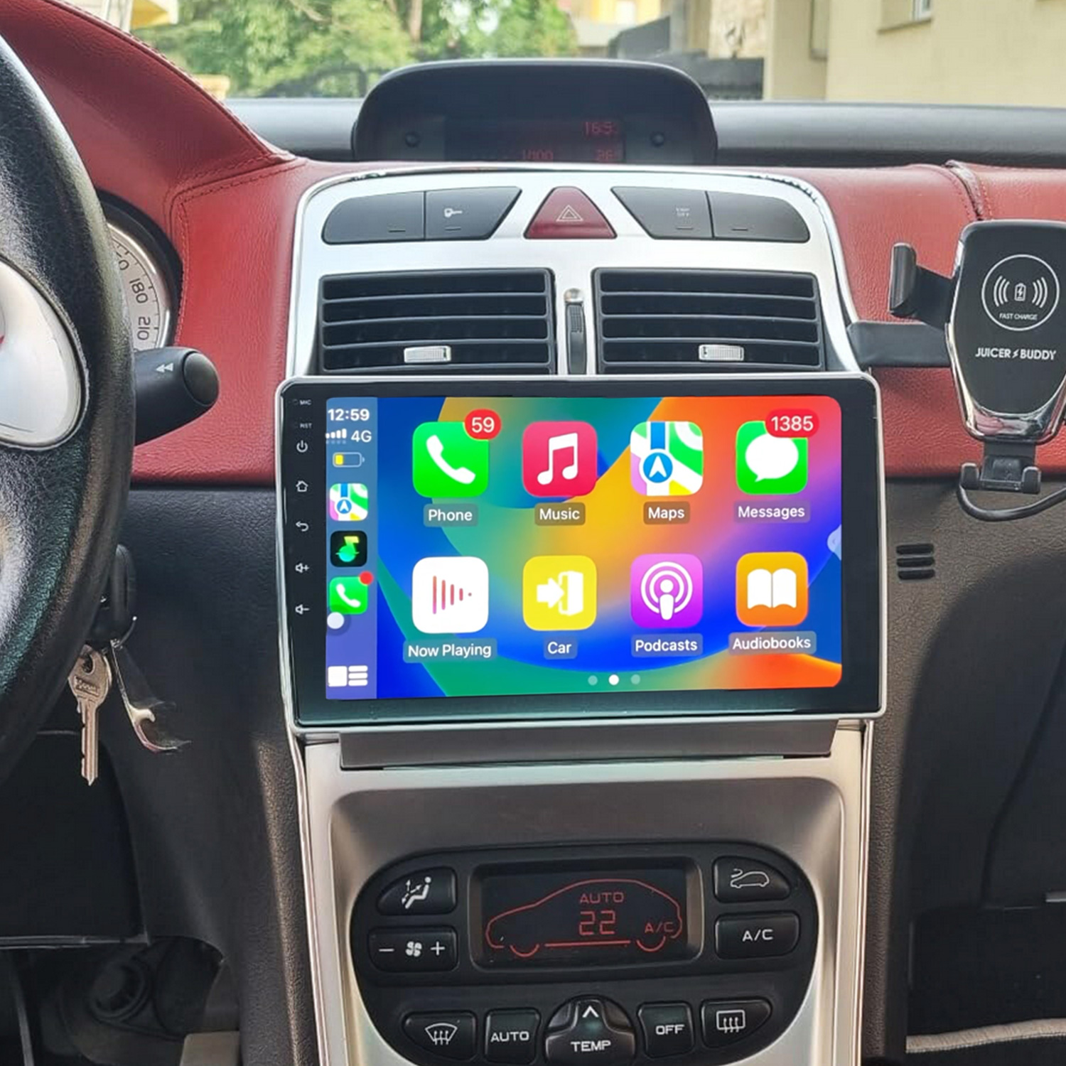 Autoinnenraum mit Touchscreen, der Apps zeigt. Lenkrad und Armaturenbrett sichtbar.