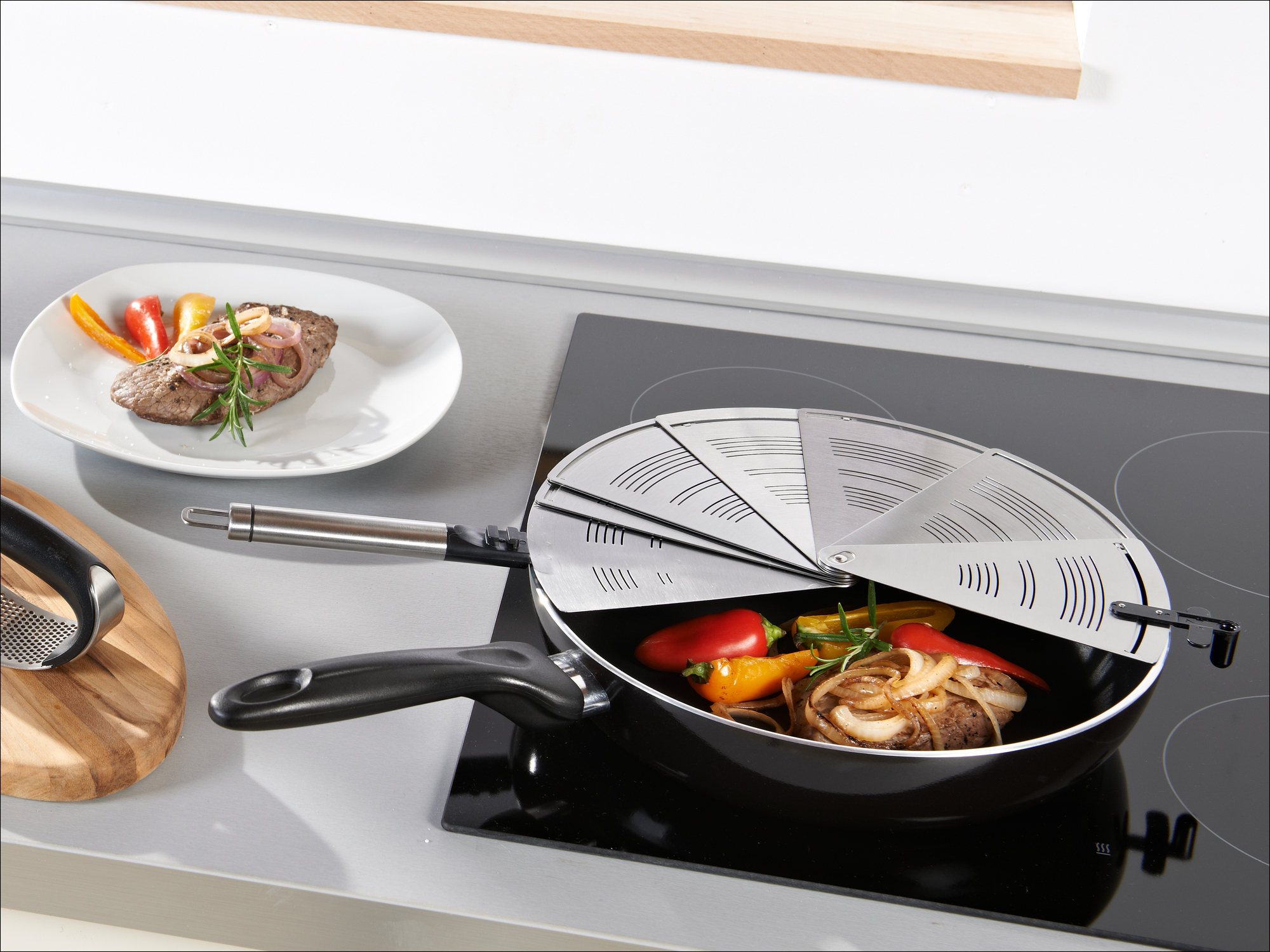 Fleisch mit Paprika und Zwiebeln in einer Pfanne auf dem Herd.