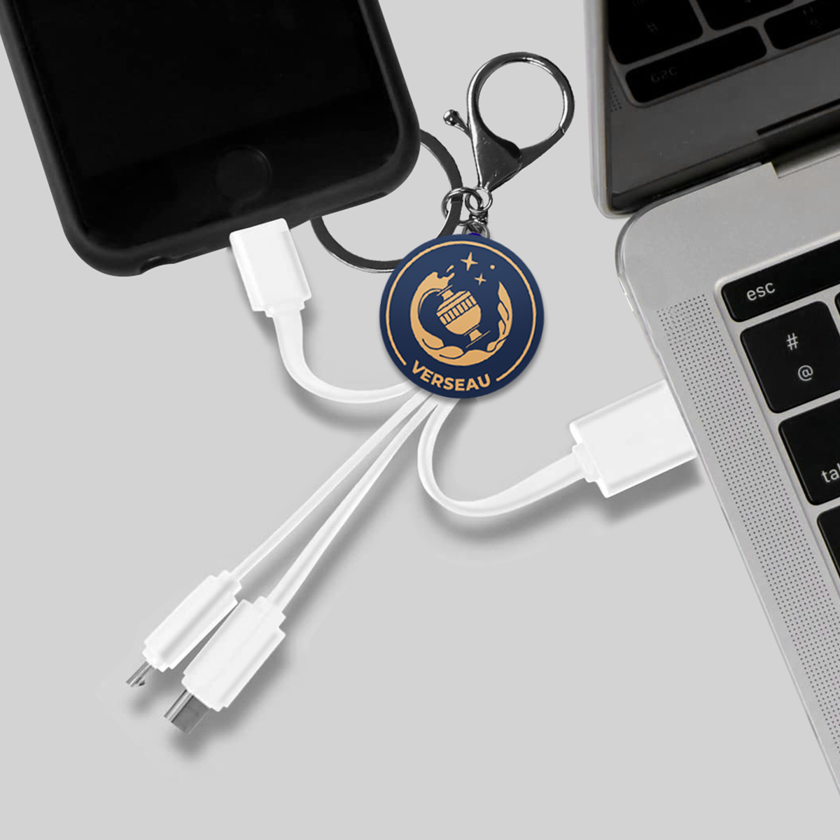 Un cavo di ricarica con ciondolo collega uno smartphone a un laptop.
