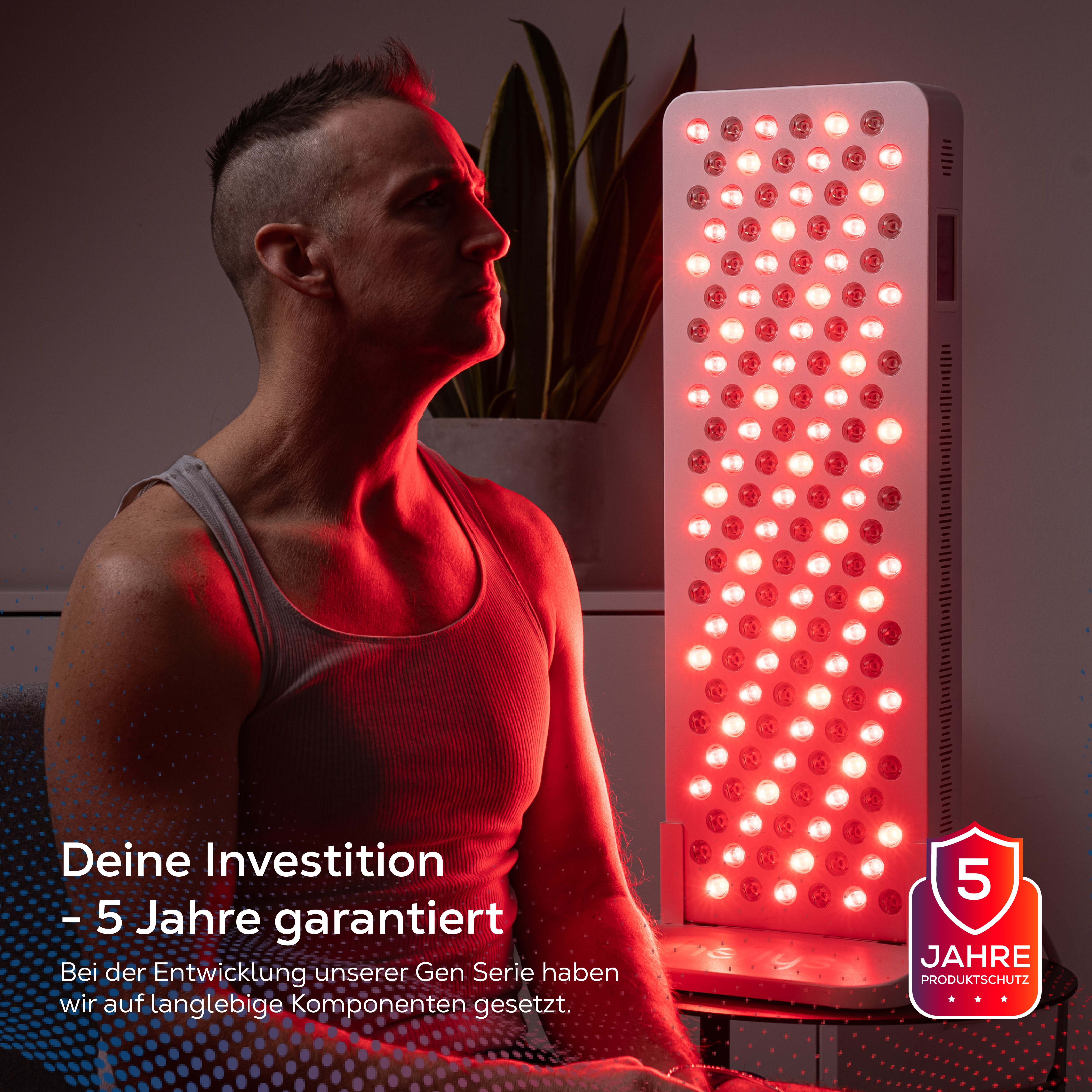 Ein Mann sitzt vor einer roten Lichttherapie-Lampe mit einem 5-Jahres-Garantiesiegel.