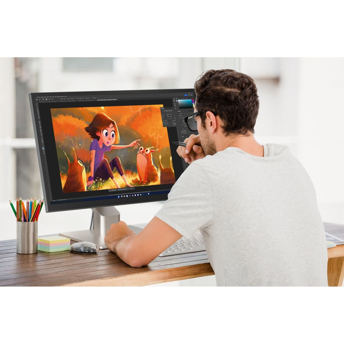 Uomo guarda schermo con disegno di ragazza e due creature.
