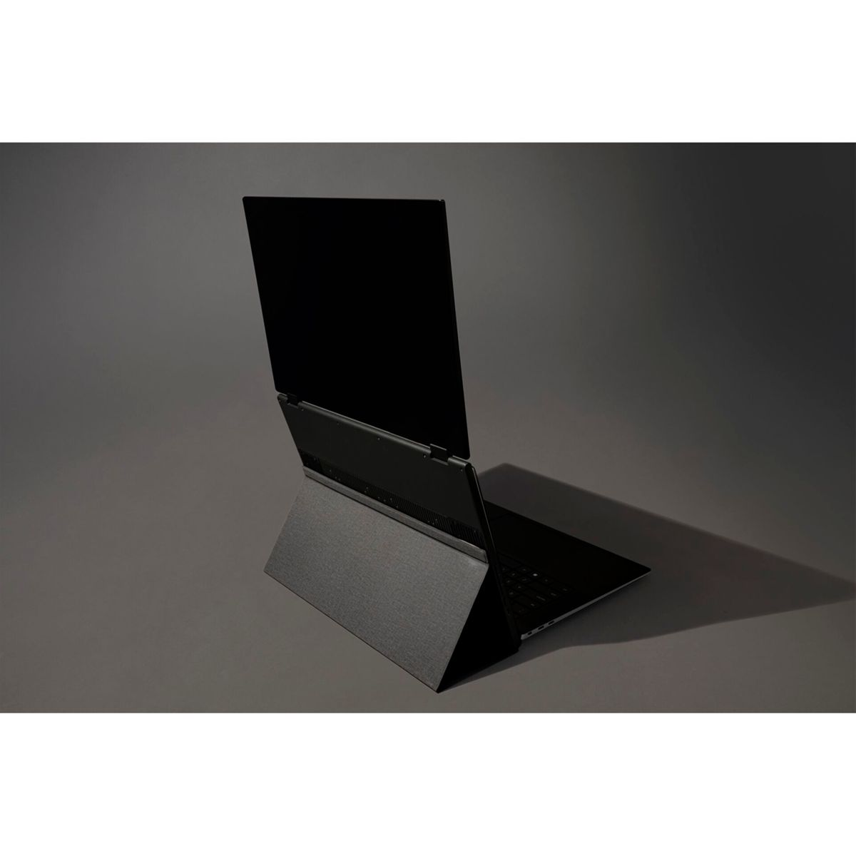 Ein schwarzer Laptop wird in einer Studioumgebung mit dunkelgrauem Hintergrund gezeigt.