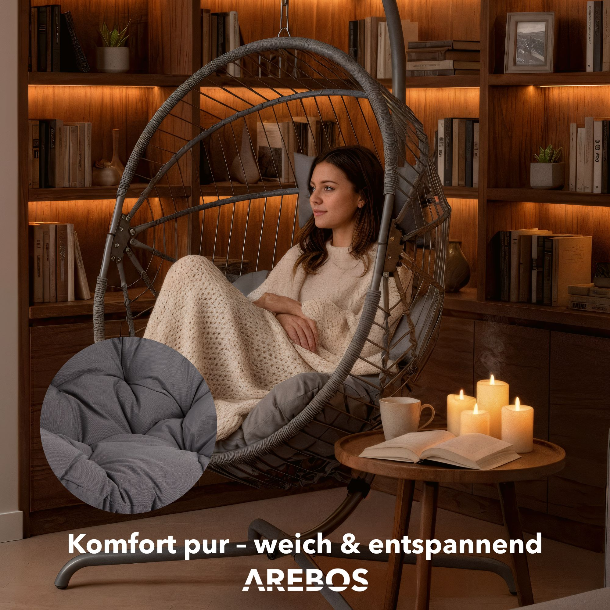 Frau in Hängesessel mit Decke, Buch und Kerzen auf einem Beistelltisch.