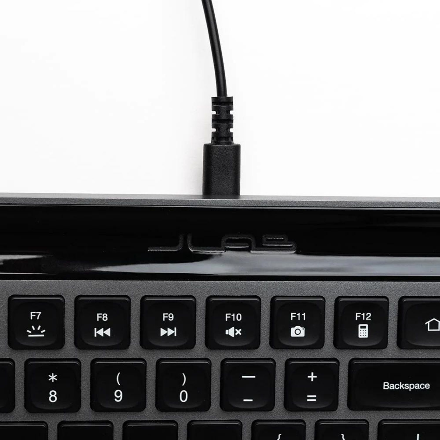 Cavo tastiera nero collegato a un laptop. Vista ravvicinata.