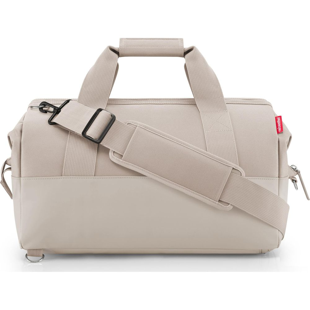 Eine beige Reisetasche mit zwei Henkeln und einem abnehmbaren Schultergurt.