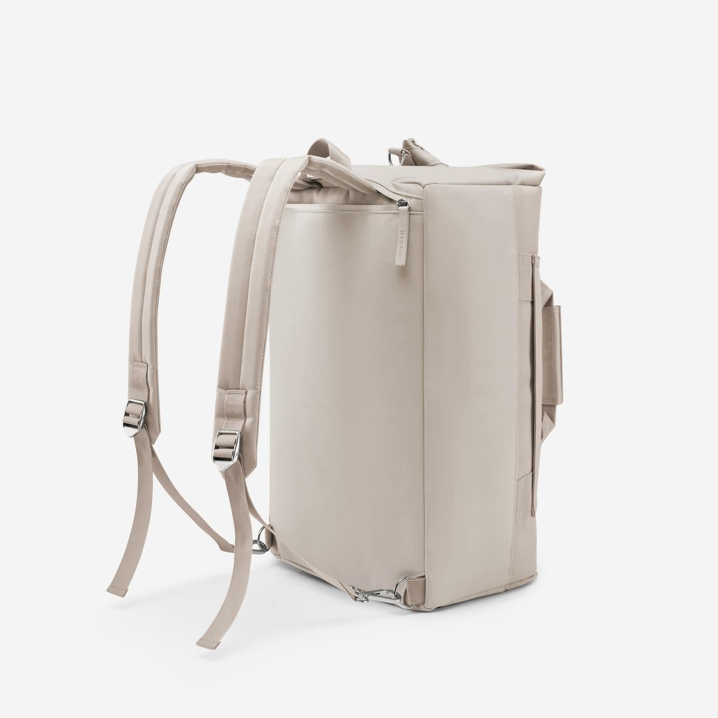 Ein hellbeiger Rucksack mit verstellbaren Trägern und silberner Hardware, von der Seite gesehen.