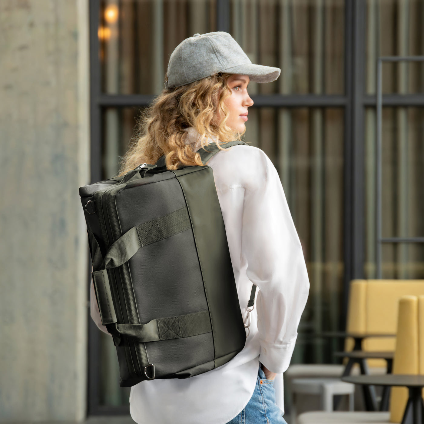 Frau mit Rucksack und Cap blickt nach rechts.