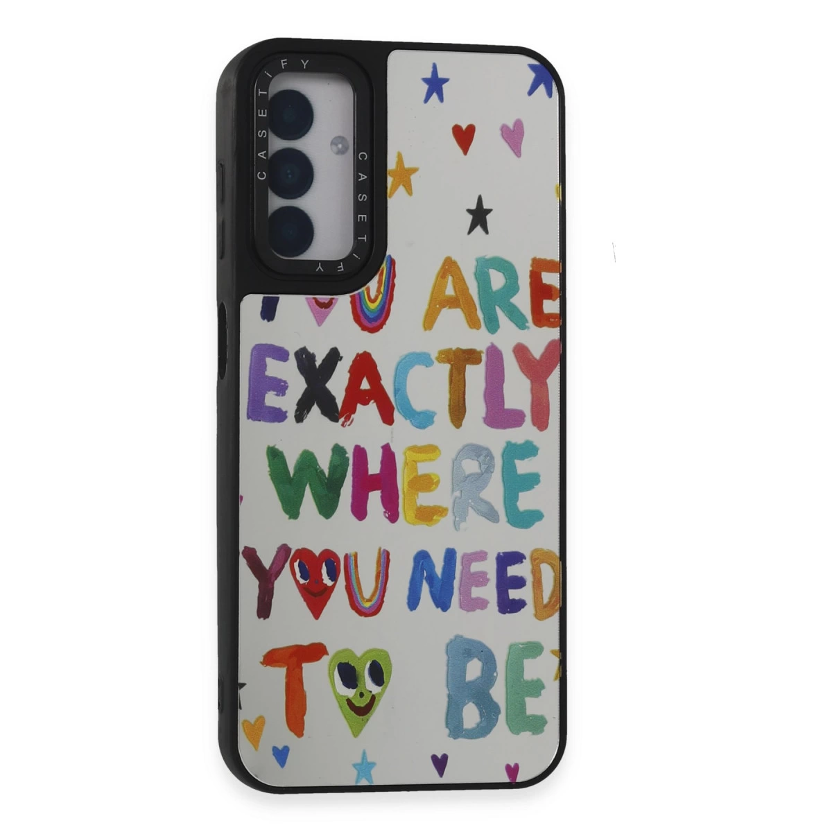 Renkli yıldızlar, kalpler ve gökkuşağı olan beyaz telefon kılıfı. Yazı: YOU ARE EXACTLY WHERE YOU NEED TO BE.