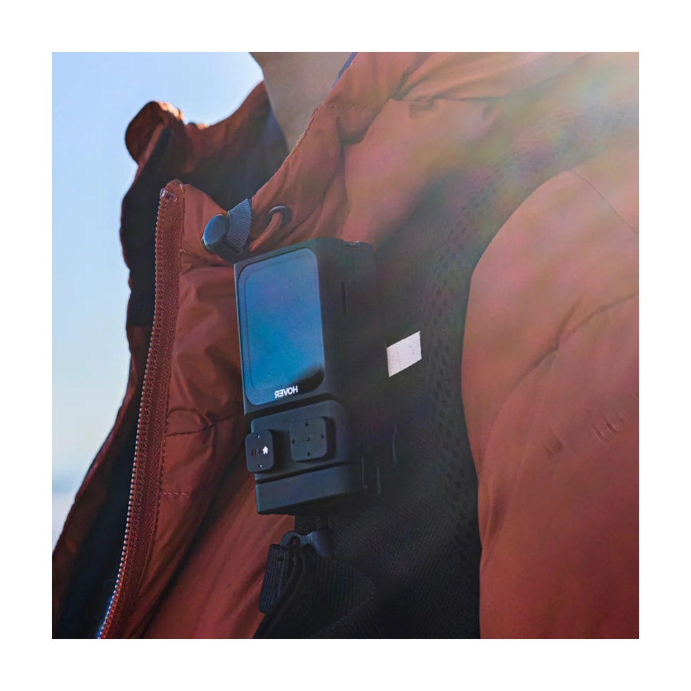 Czarny aparat jest przymocowany do czerwonej kurtki.