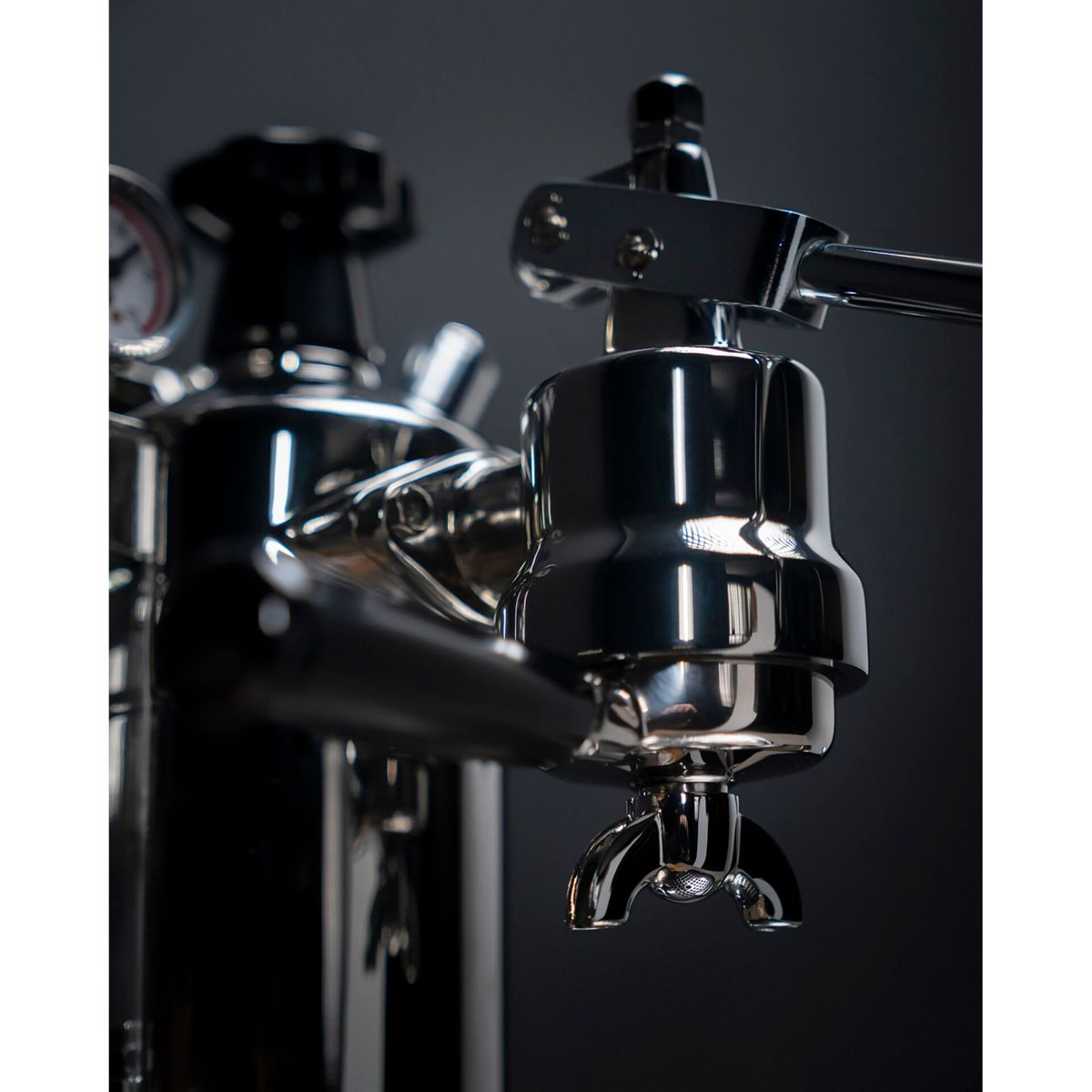 Nahaufnahme einer glänzenden Chrom-Espressomaschine mit Hebel und Siebträger.