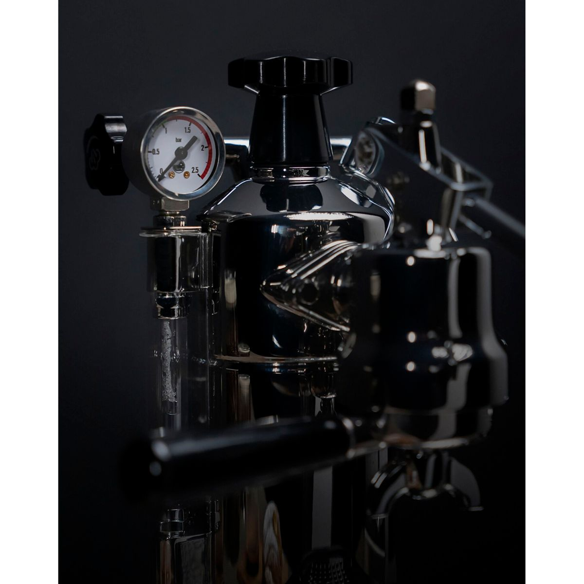 Eine Nahaufnahme einer glänzenden Espressomaschine mit Manometer und Hebel.