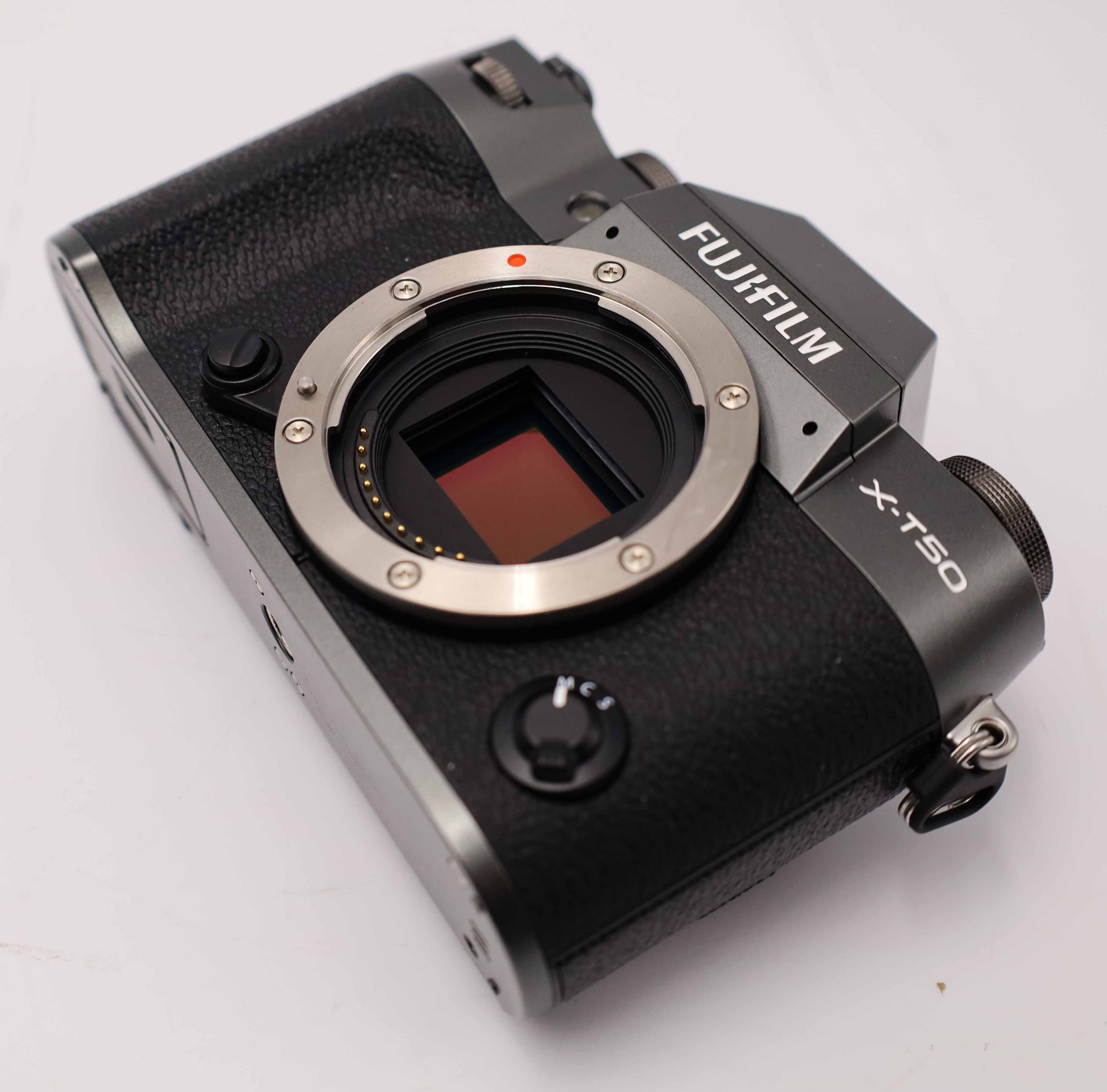Grijze Fujifilm X-T50 camera met zwart lederen grip en open lensvatting.