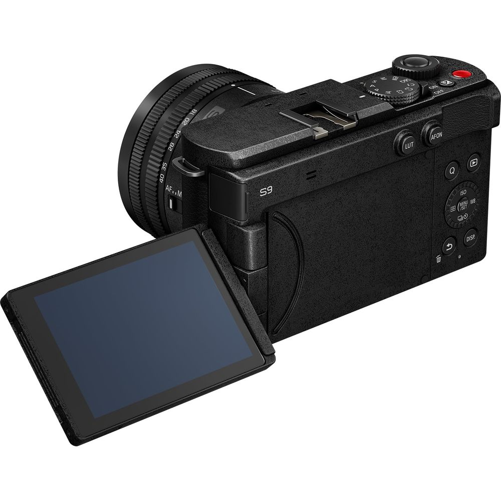 Schwarze Digitalkamera mit schwenkbarem Bildschirm und Objektiv mit Zoomring.