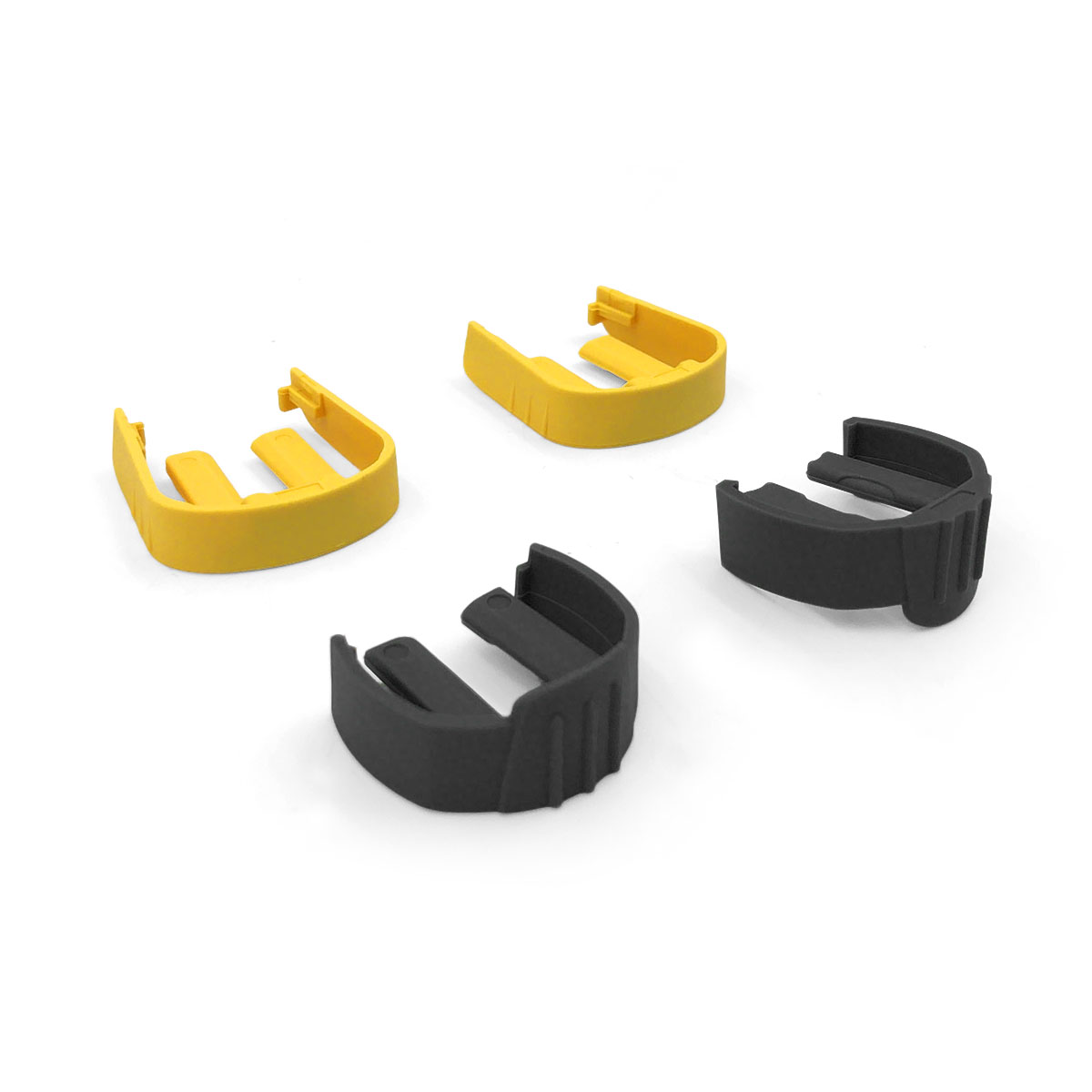 Cztery plastikowe części: dwie żółte i dwie czarne, na białym tle.