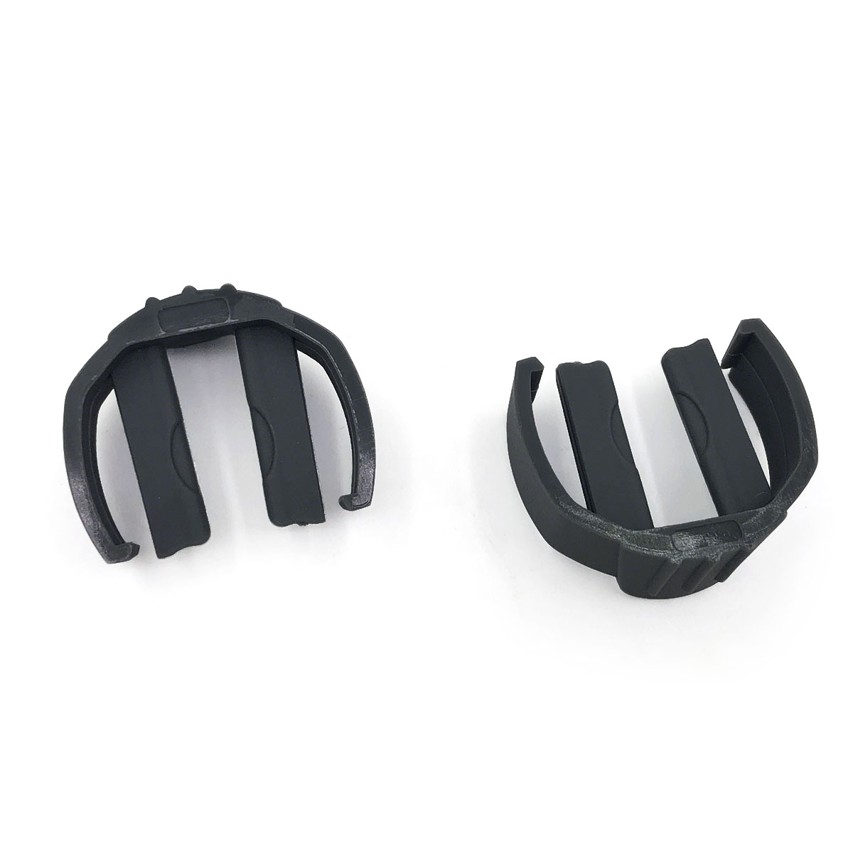 Dwa czarne plastikowe części ze szczelinami na białym tle.