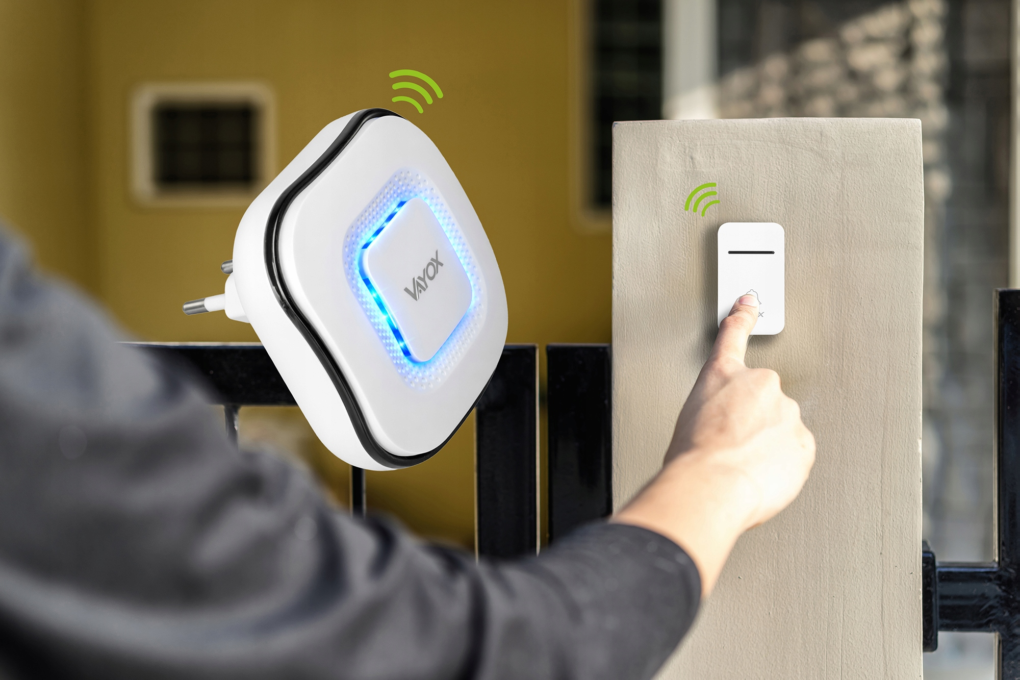 Osoba naciska dzwonek do drzwi, wtyczka z niebieskim światłem w tle.