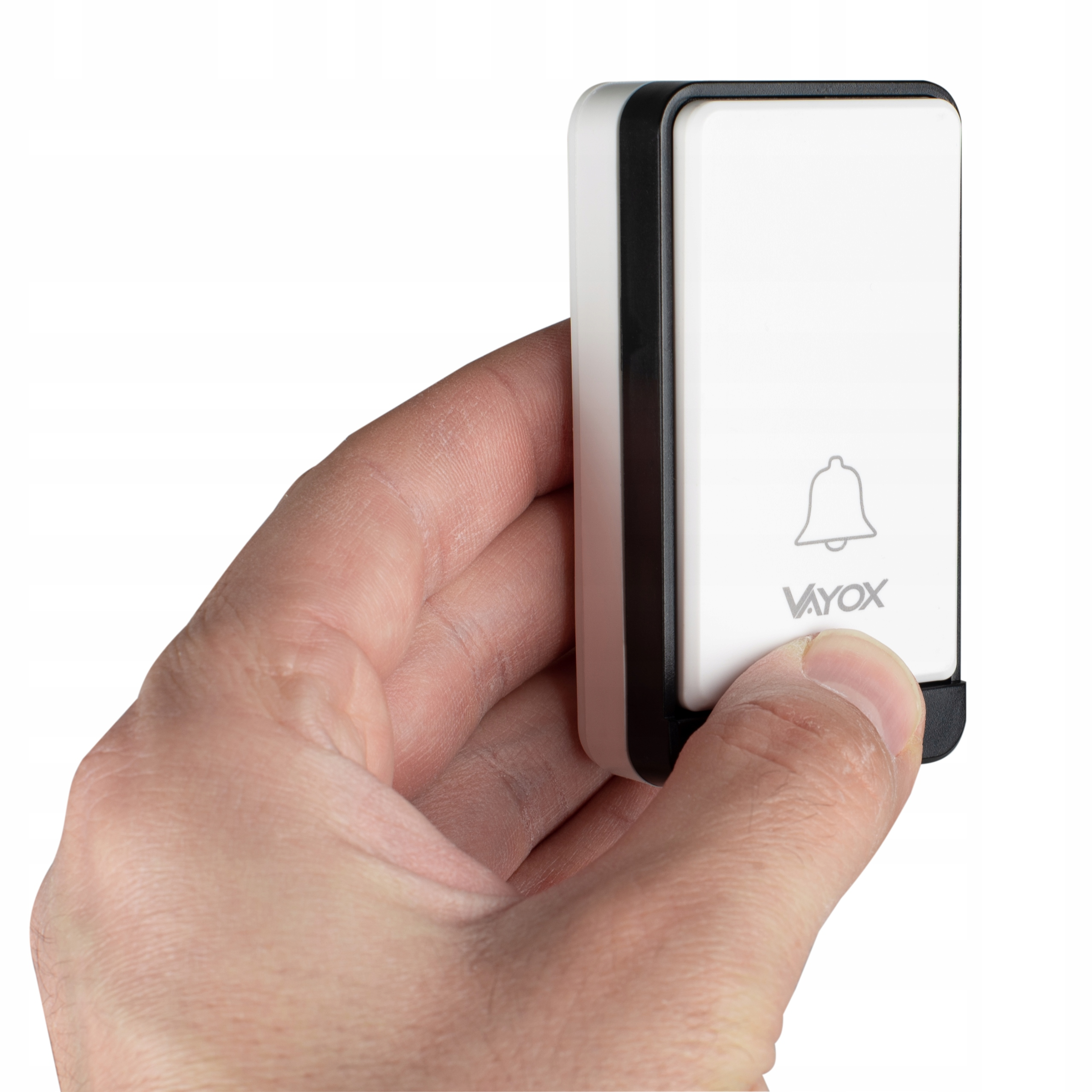 Kciuk trzyma biały przycisk dzwonka Vayox z ikoną dzwonka.