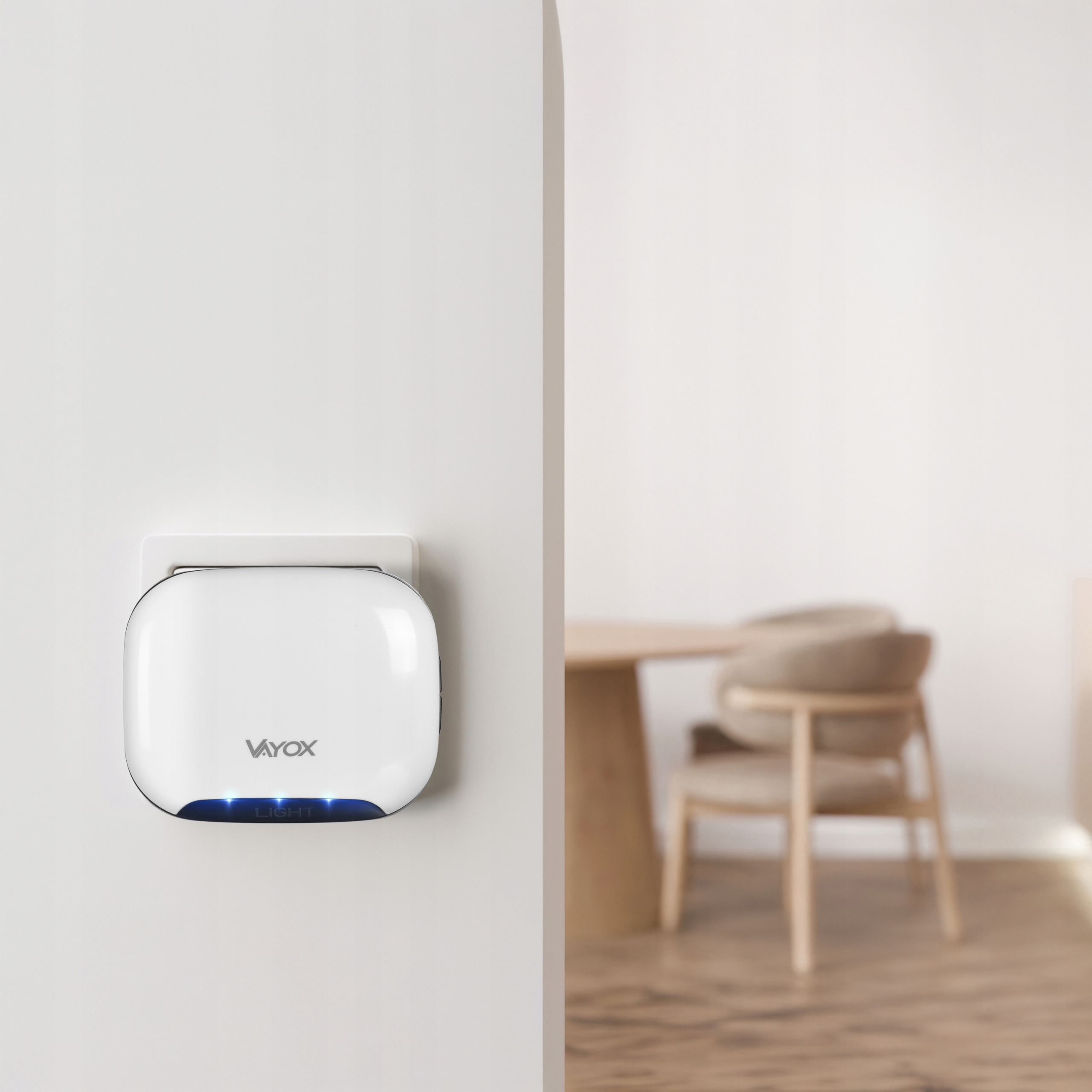 Białe urządzenie Vayox z niebieskimi światłami na ścianie, jadalnia w tle.