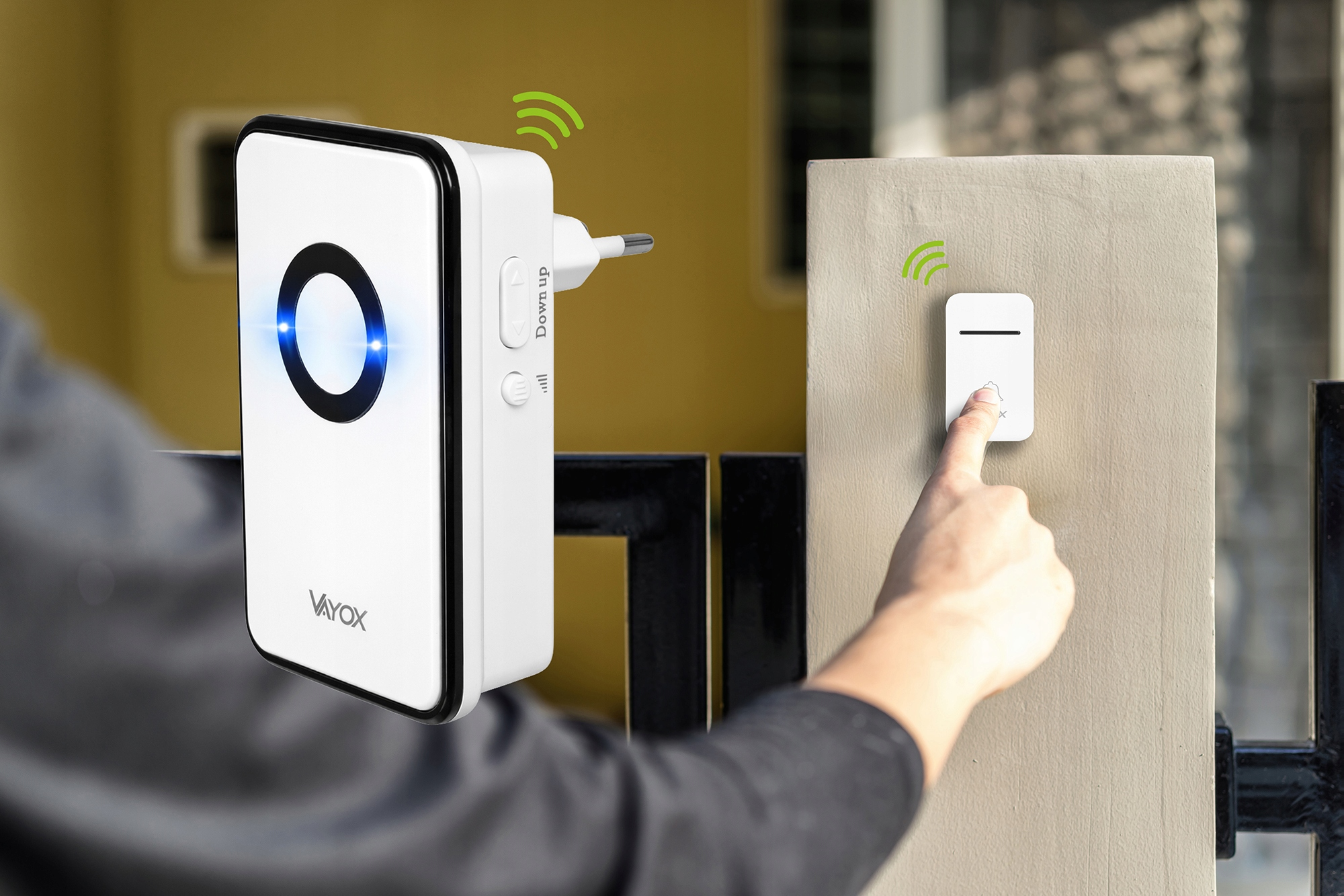 Palec naciska biały dzwonek. Wtykany odbiornik świeci na niebiesko.