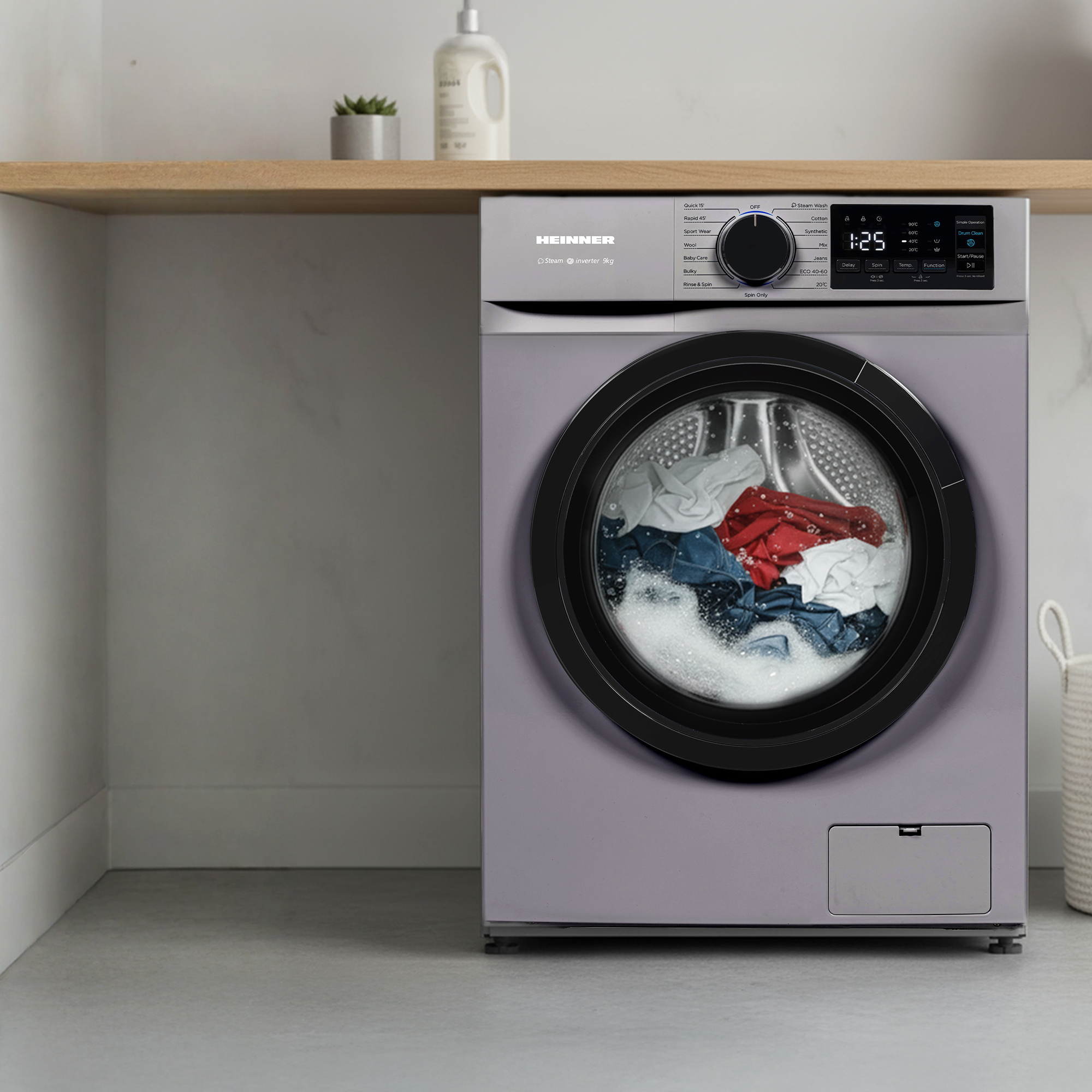 Une machine à laver grise avec une fenêtre ronde montrant du linge à l'intérieur.