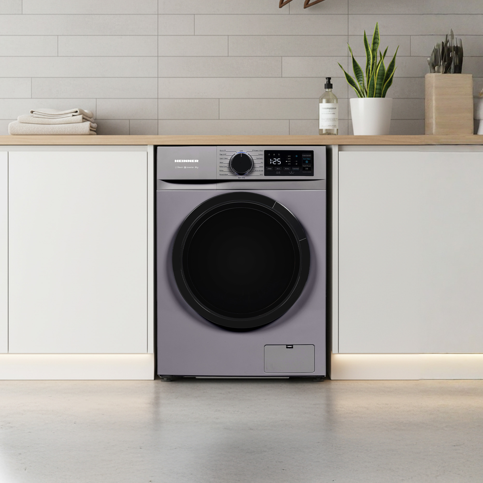 Gray washing machine with a black door, set on a wooden counter.