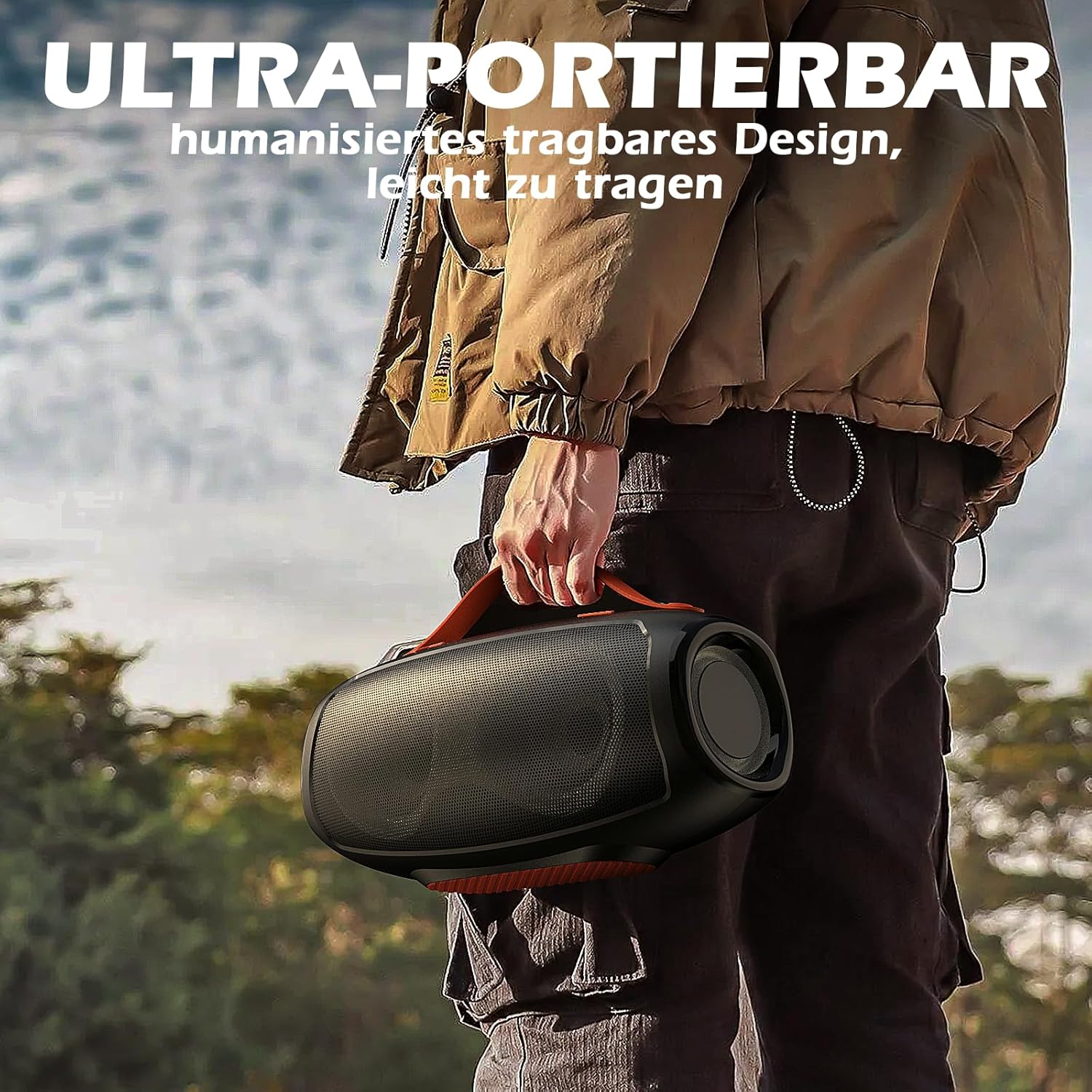 Mężczyzna trzymający przenośny głośnik na zewnątrz. Głośnik jest czarny z pomarańczowymi akcentami.