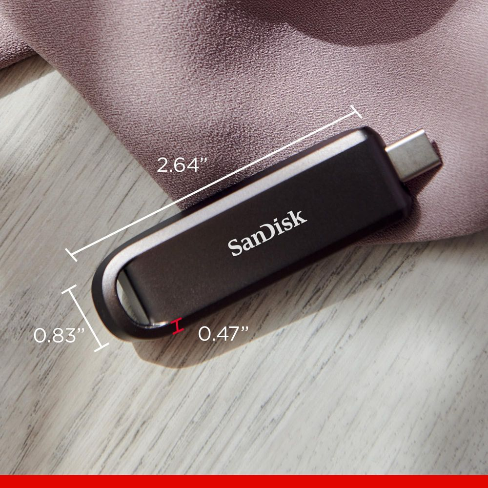 Schwarzer SanDisk USB-Stick mit Maßen 2,64x0,83x0,47 Zoll auf Stoff.