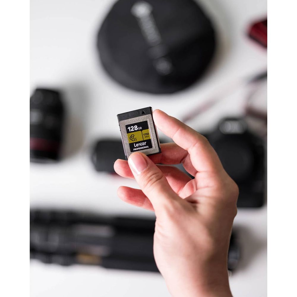 Eine Hand hält eine 128GB Lexar CFexpress-Speicherkarte vor einer Kamera.