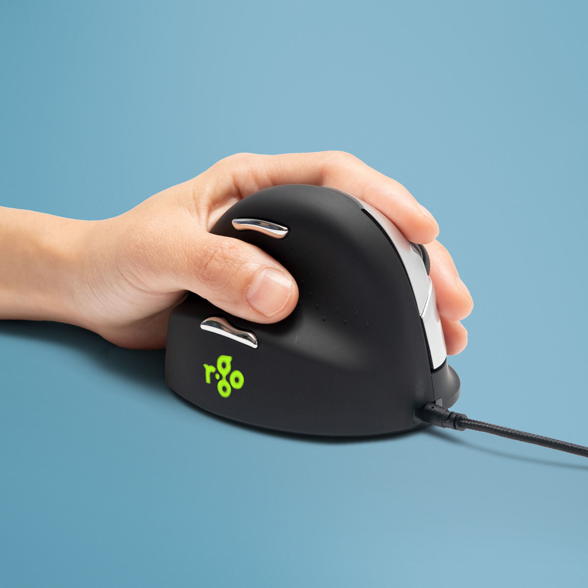 Eine Hand hält eine schwarze vertikale Maus mit silbernen Akzenten auf blauem Hintergrund.