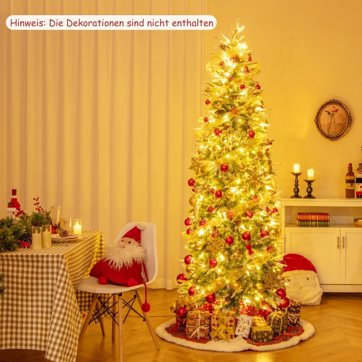 Een verlichte kerstboom met rode en gouden ornamenten staat in een kamer.