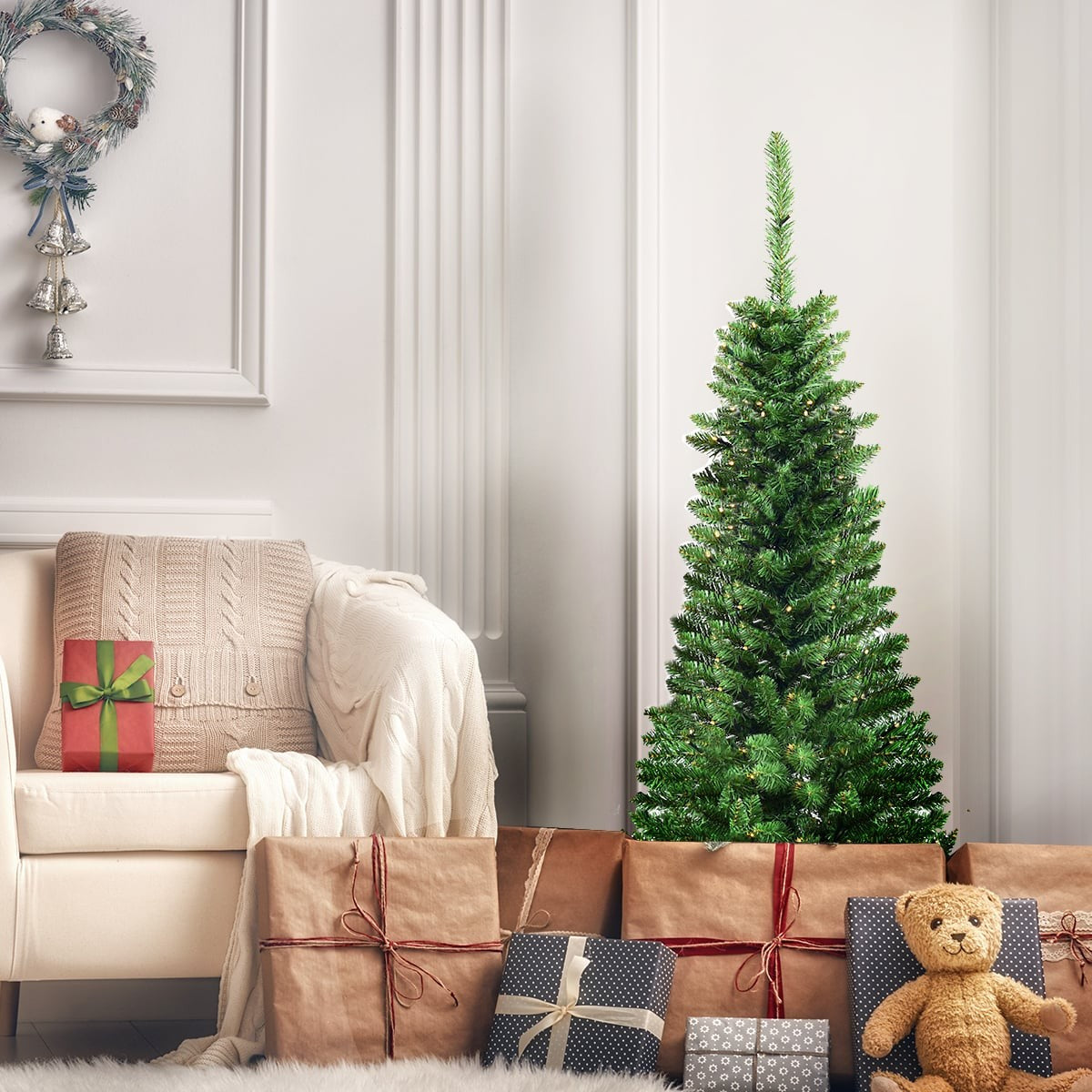 Een versierde kerstboom staat met cadeaus en een teddybeer in een gezellige kamer.